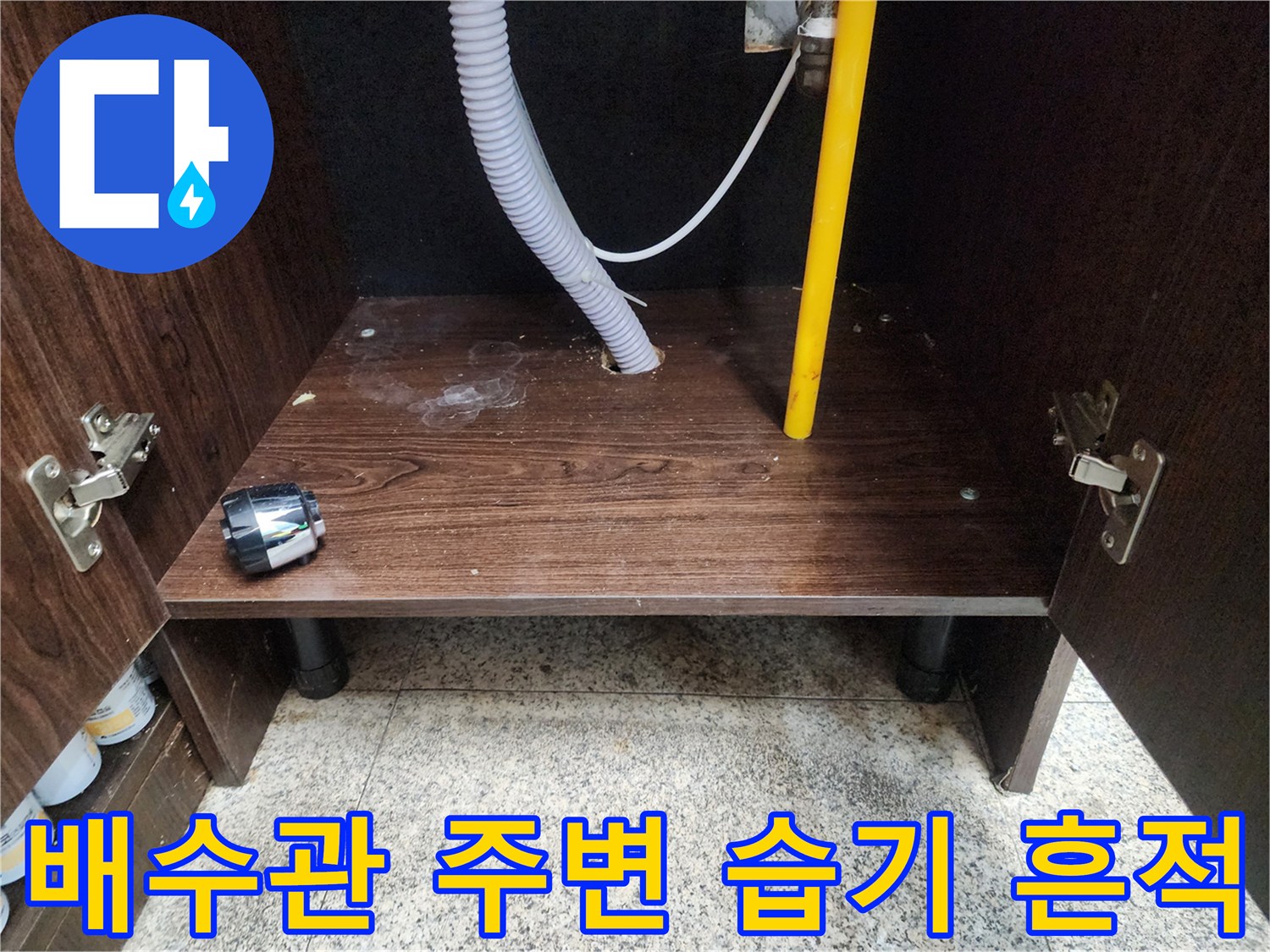 물샘 증상이 나타난 싱크대 내부 배관 및 바닥재 모습