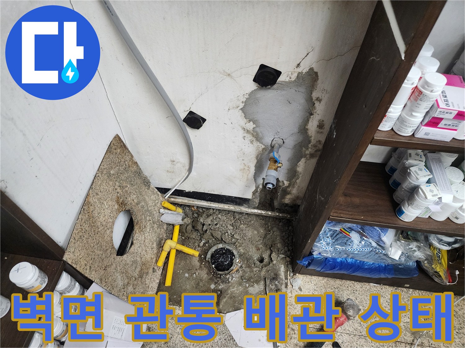 싱크대 아래 벽면 배관 부근의 젖은 흔적과 노후된 모습