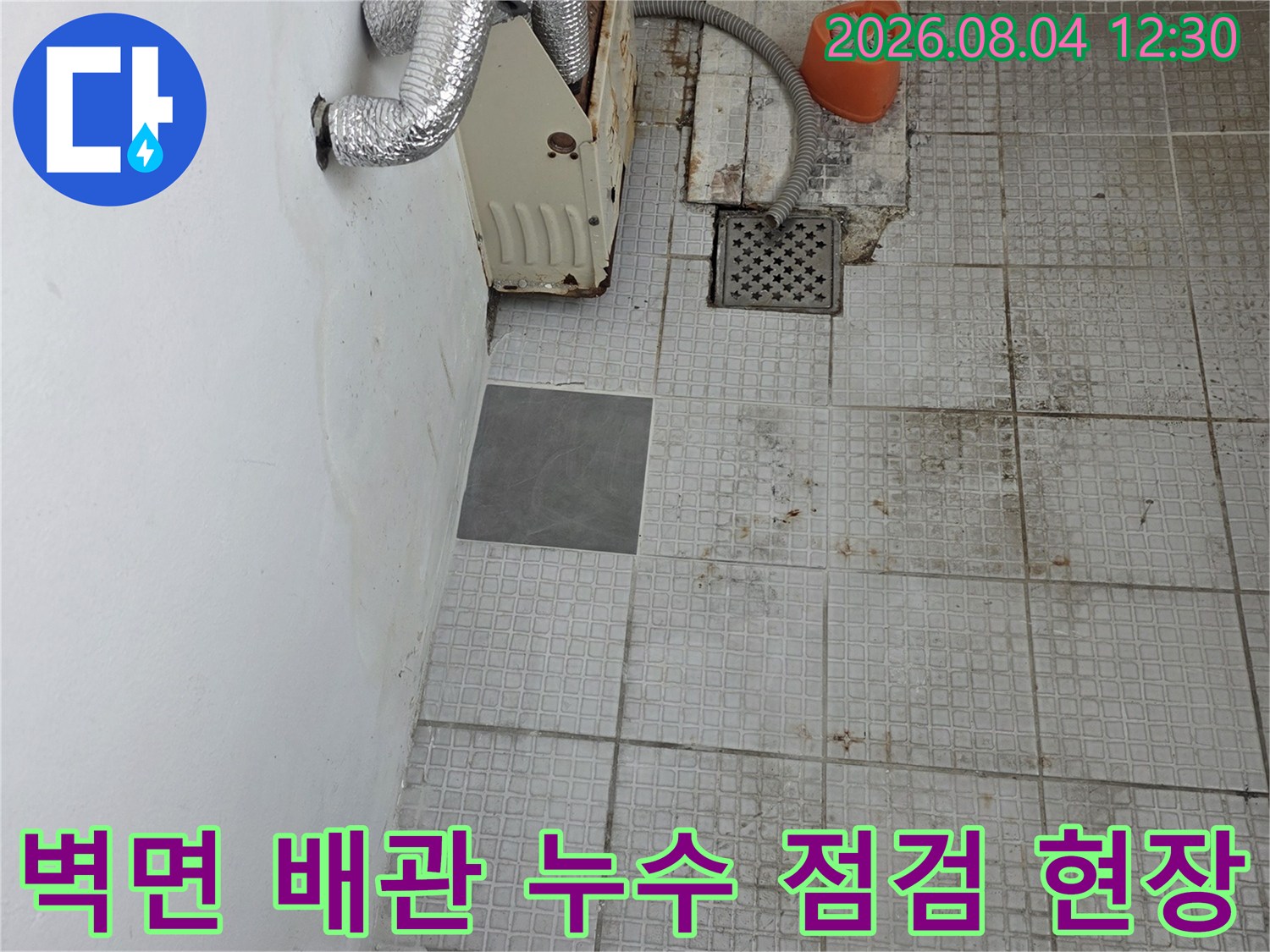 타일 제거 후 노출된 은색 단열재 배관과 수리용 장비 배치 상태