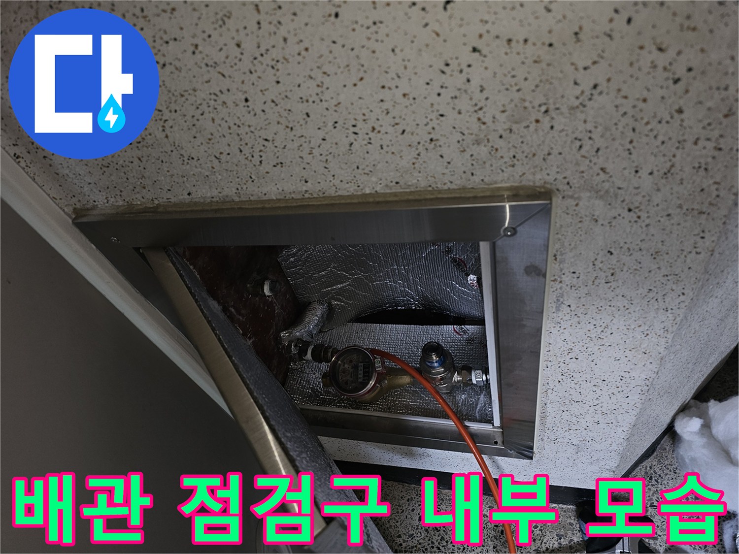 천장 점검구 안쪽의 배관 연결 부위와 압력계 - 배관 내 기밀 유지를 확인하는 공압 테스트 중