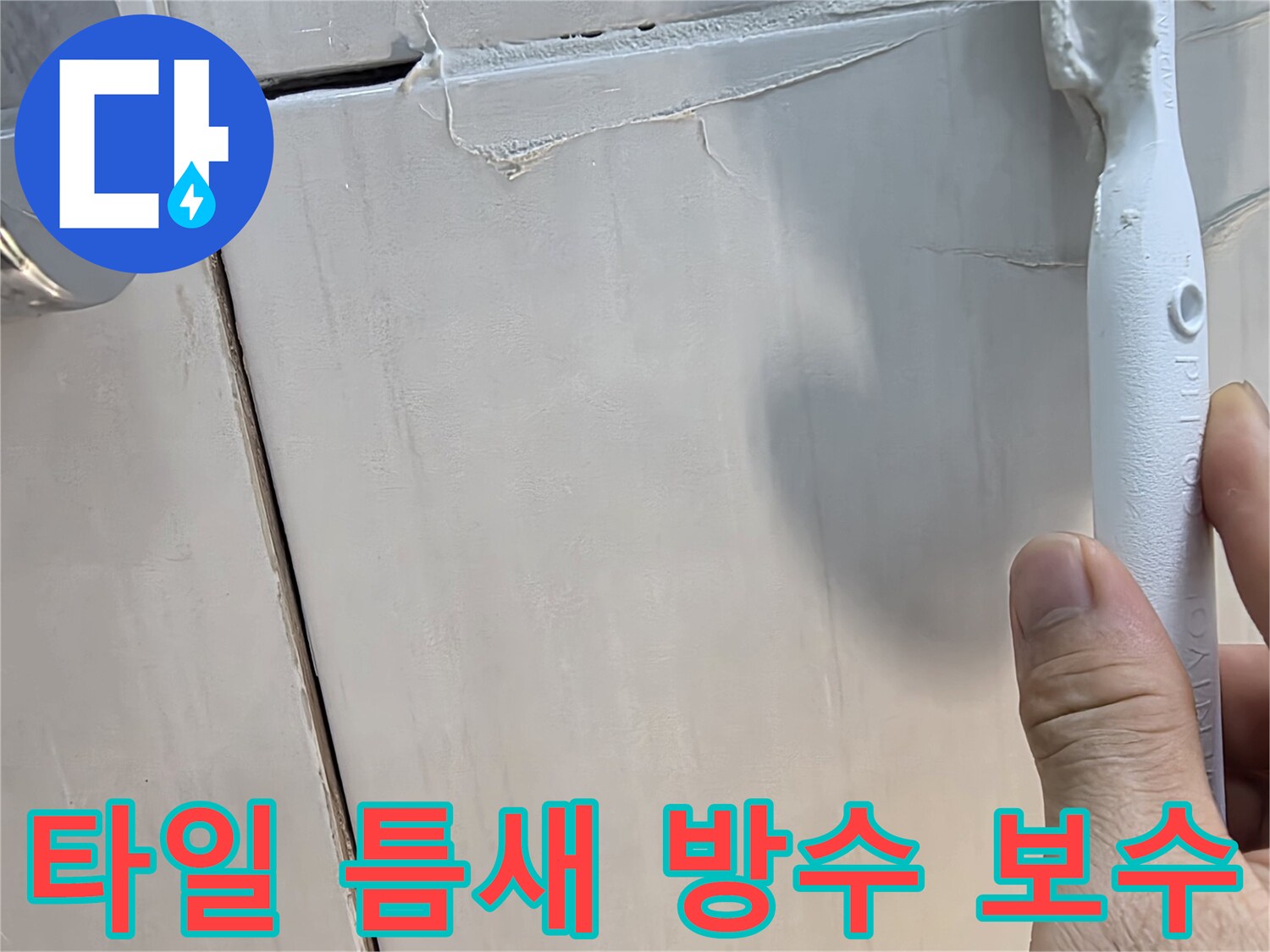 벌어진 타일 사이 공간에 하얀색 방수재를 채우는 모습