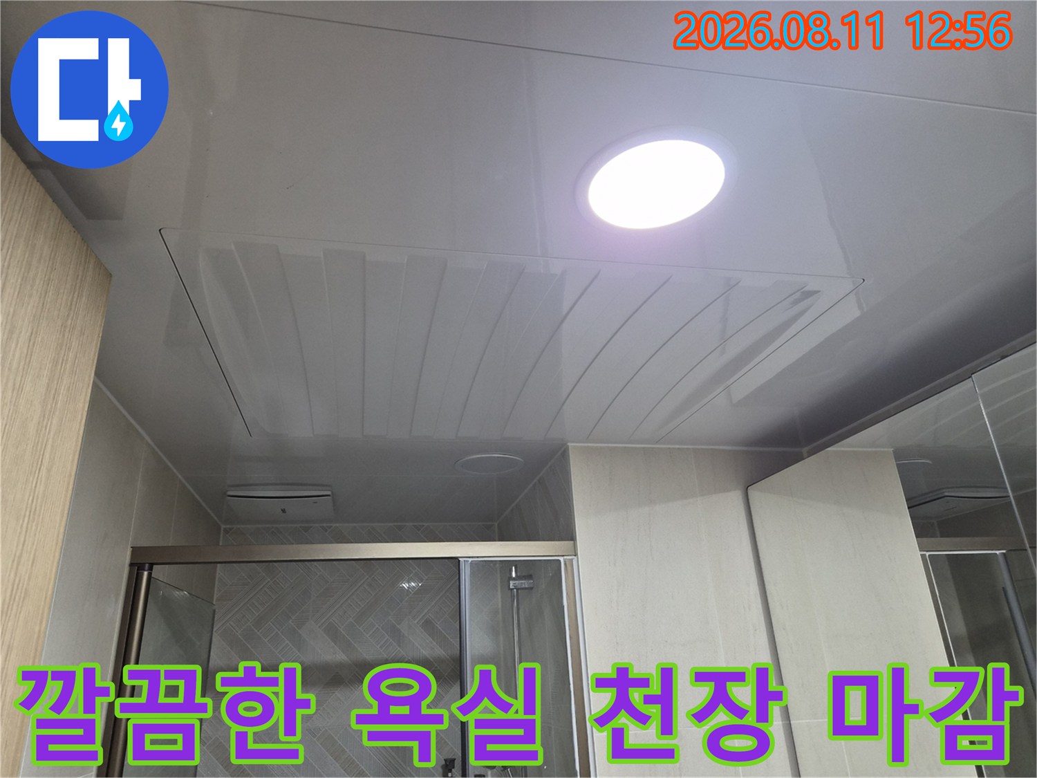 조명이 매립된 깨끗하게 시공된 욕실 천장 패널입니다.