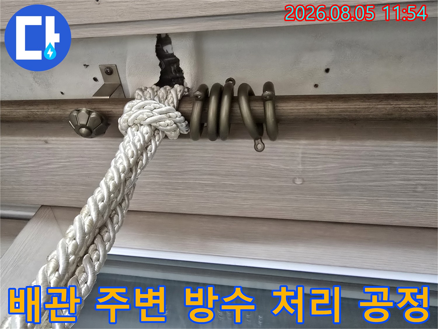 베란다 천장 배관과 밧줄로 고정된 구조물의 모습