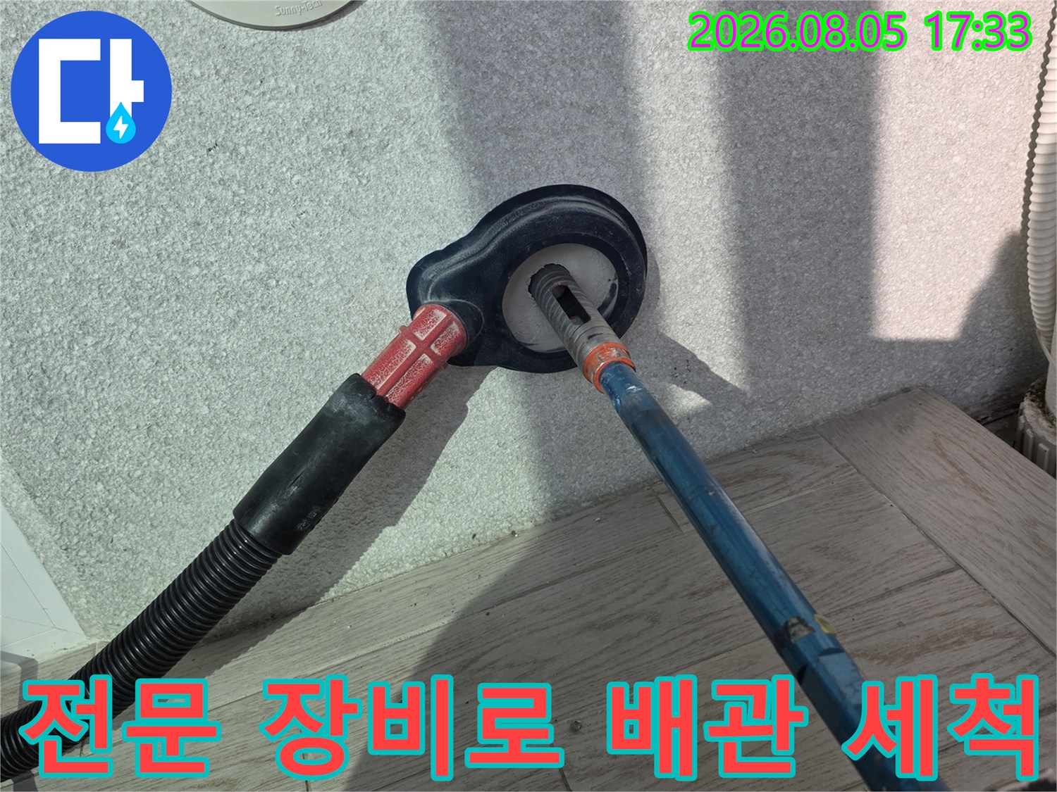 전동 기기를 사용하여 막힌 배수구를 파쇄하고 소통시키는 현장 모습