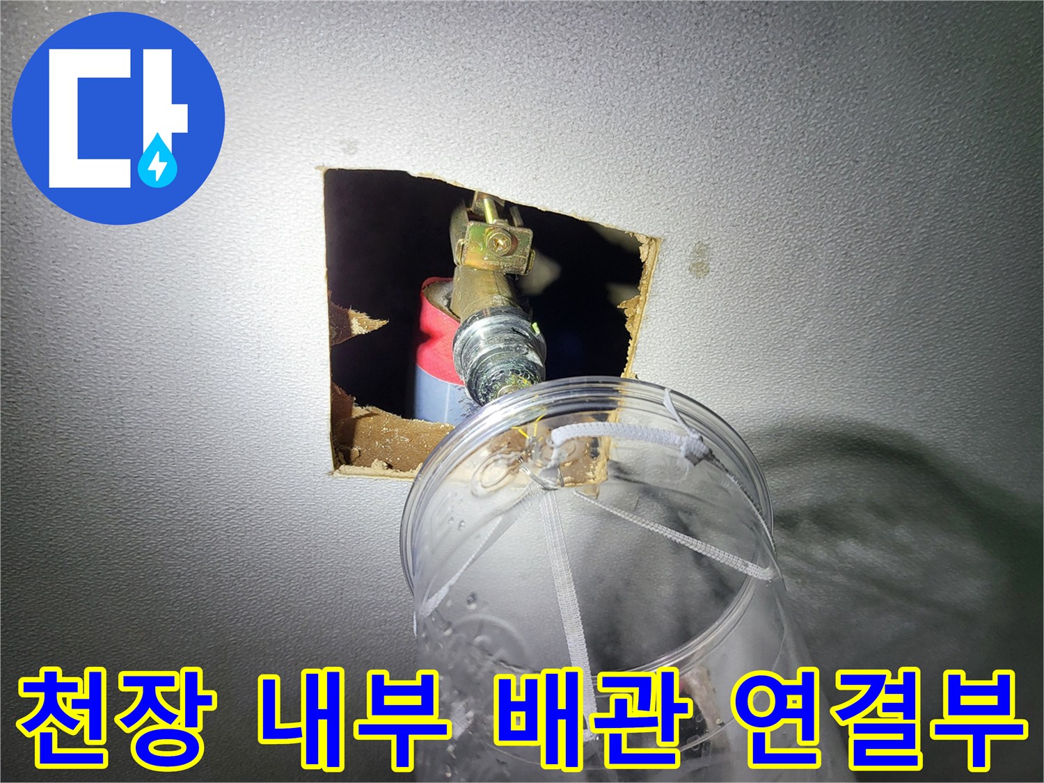 천장 타공 부위 내부에 노출된 수도 배관과 연결 부속의 모습