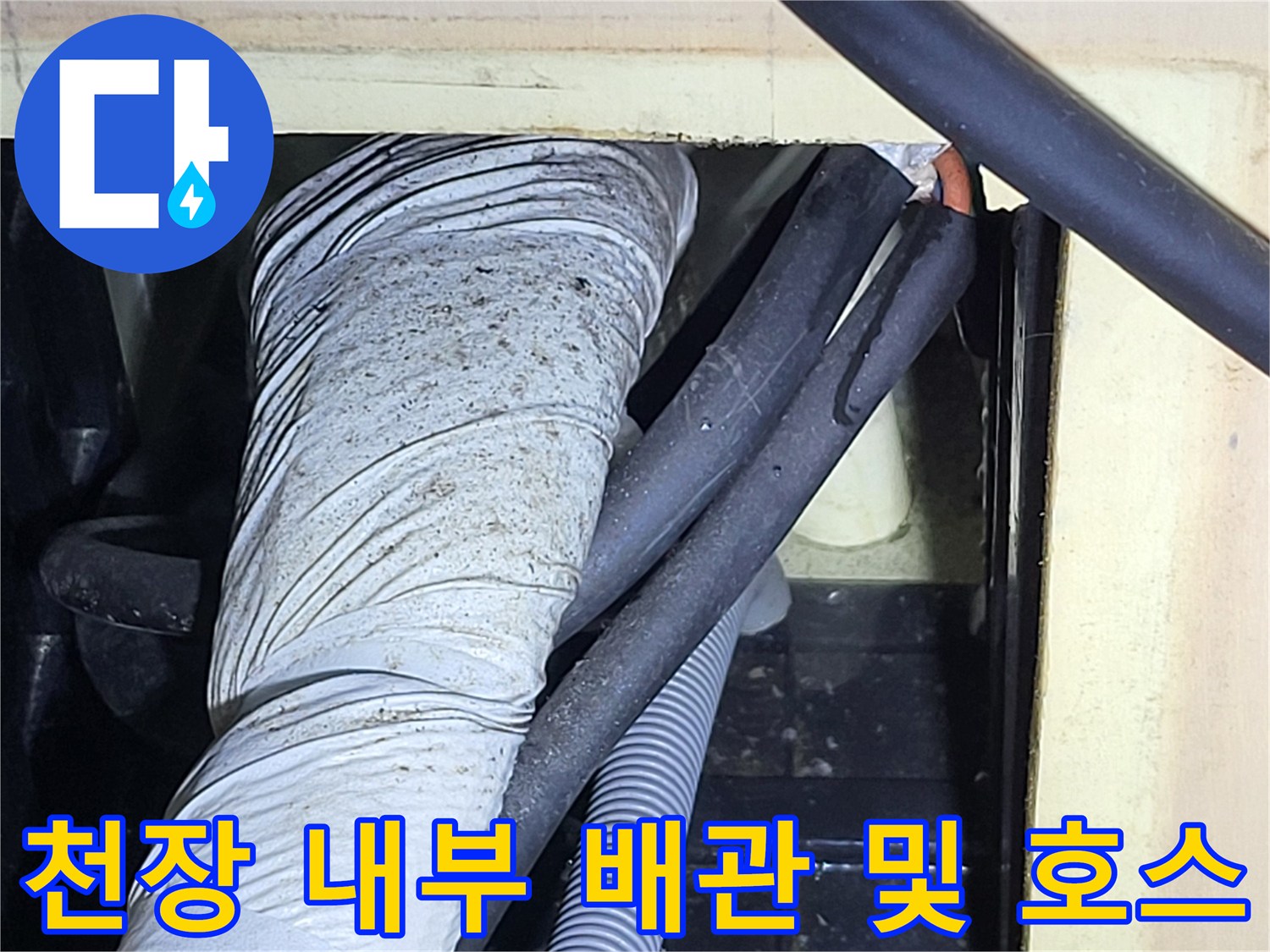 하얀색 보온재 배관과 회색 주름관이 통과하는 천장 내부 모습