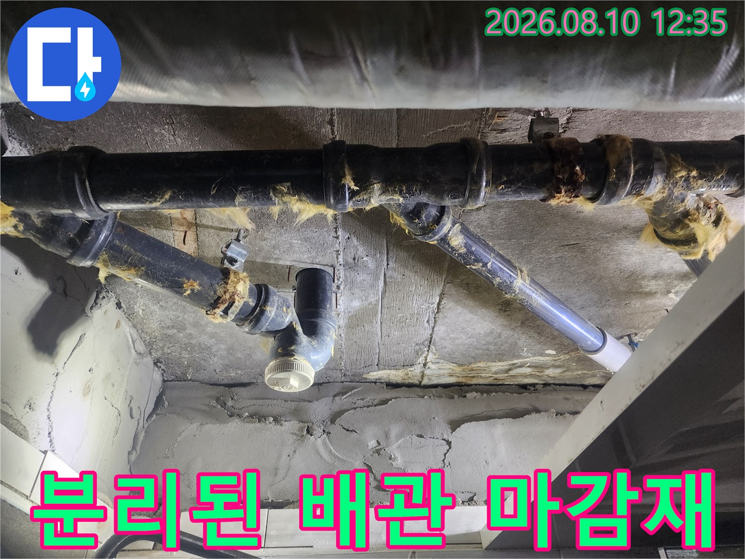 배관 연결 부위의 낡은 보온재와 검정색 하수관