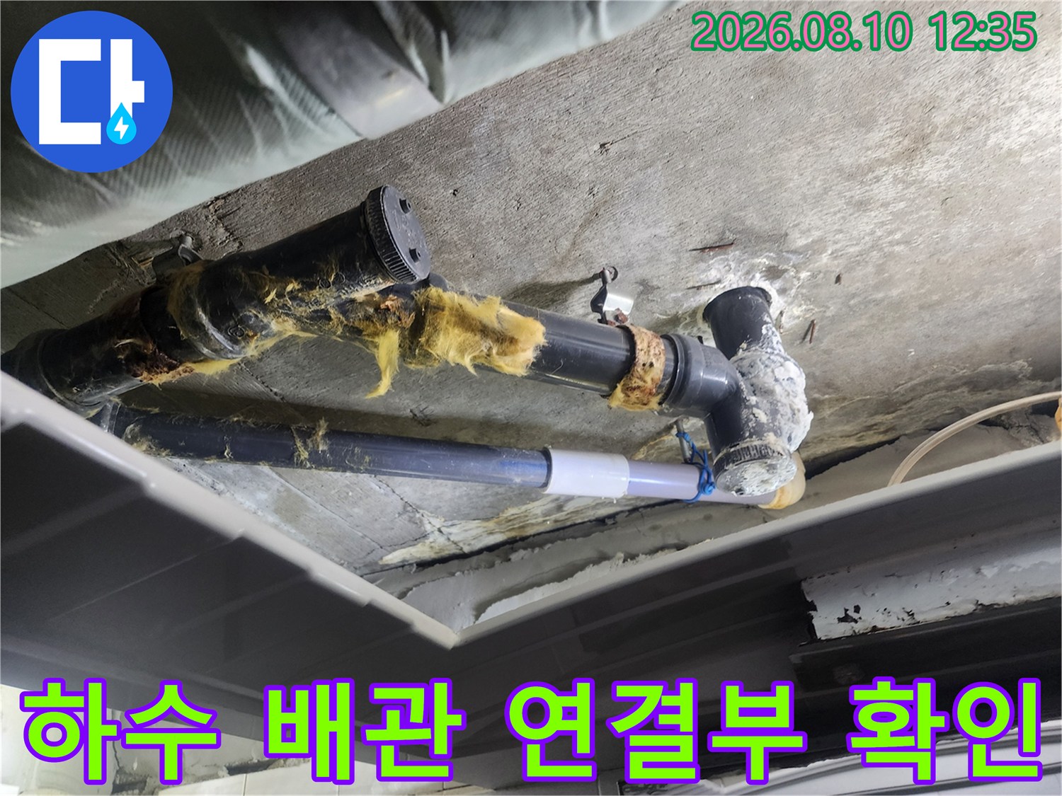 천장 내부의 낡은 하수관과 보온재가 손상된 배관 연결 부위 사진입니다.