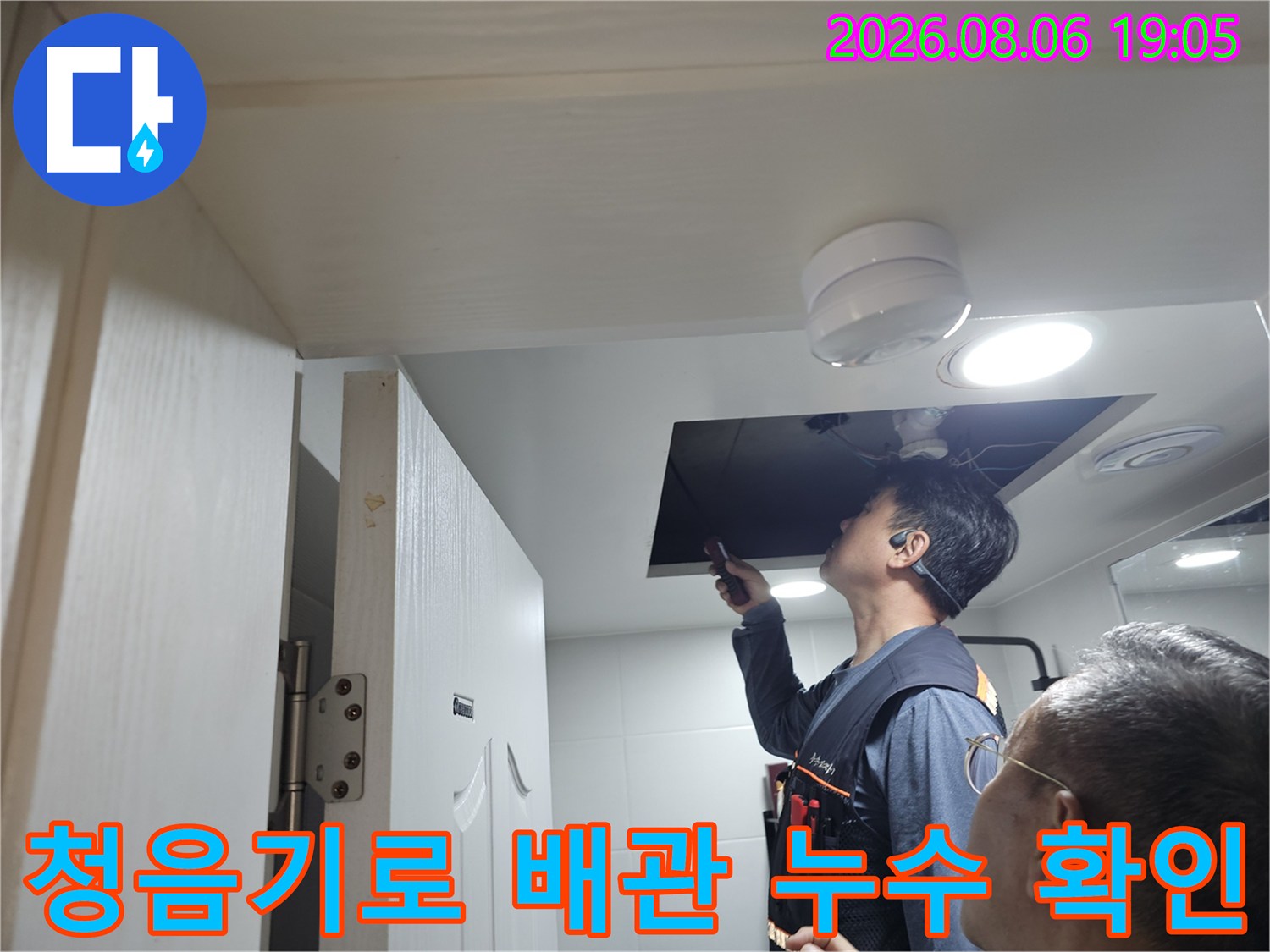 천장 안쪽의 배관 시스템을 청음 장비로 정밀하게 체크하며 파손 부위를 찾는 장면