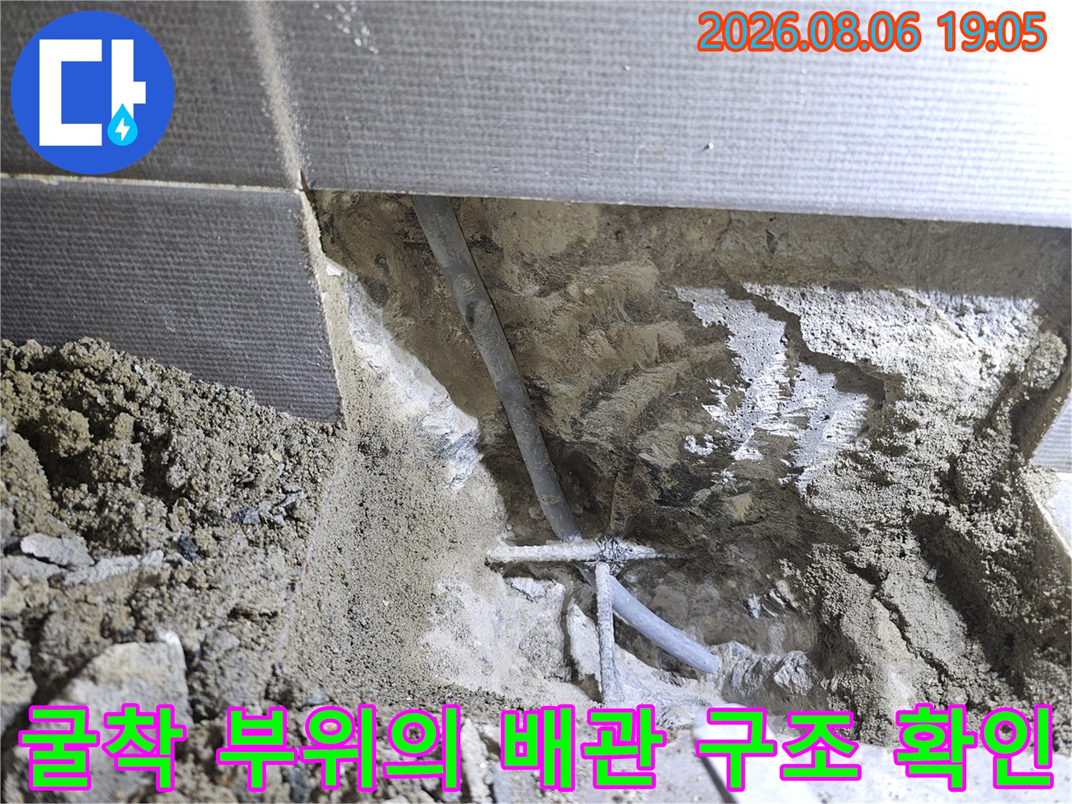 화장실 벽면을 파내어 노출시킨 매립형 배관과 주변 기초 시멘트