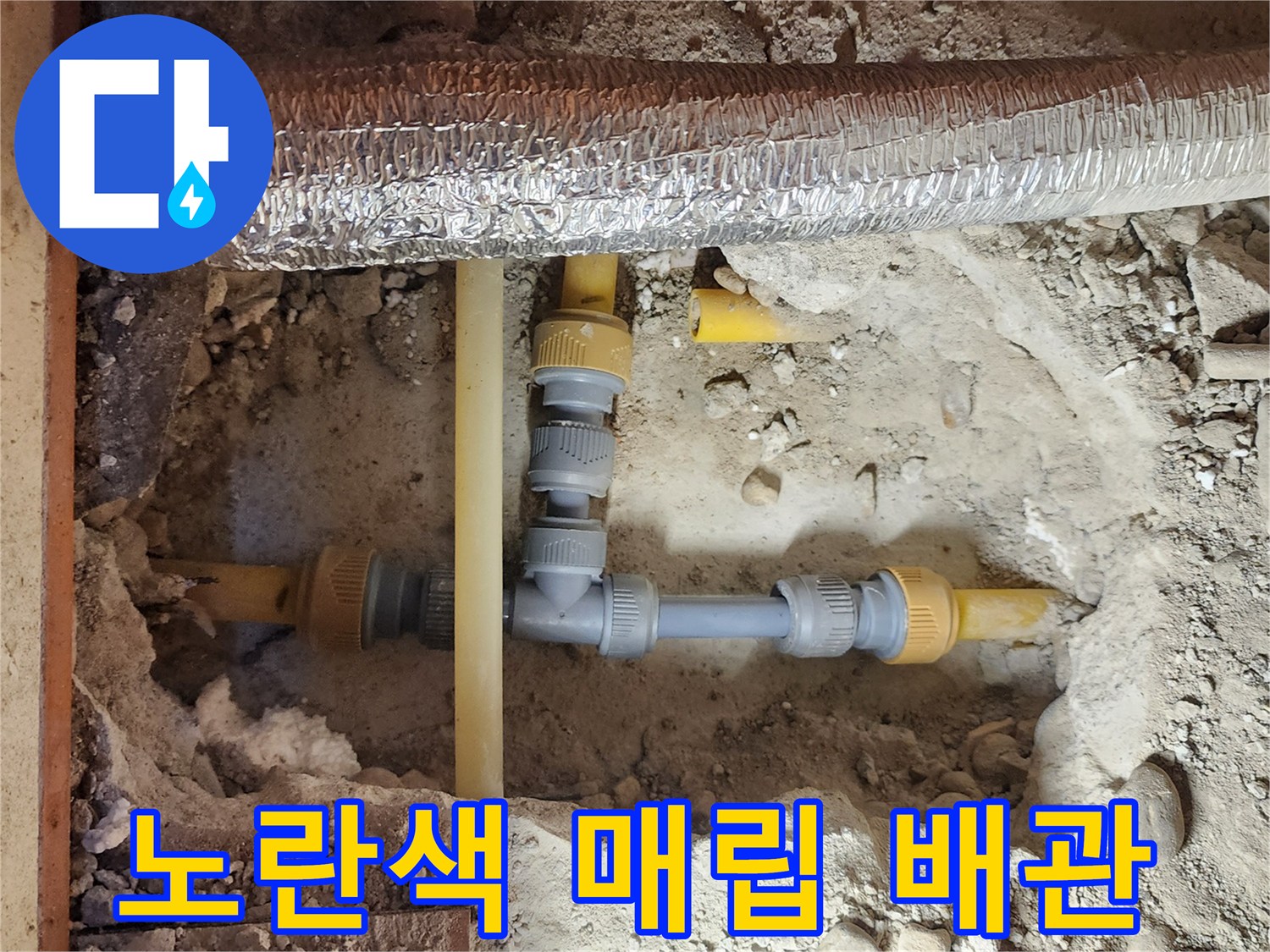 공사 중 드러난 흙과 자갈 사이의 노란색 수도 배관 연결 부위