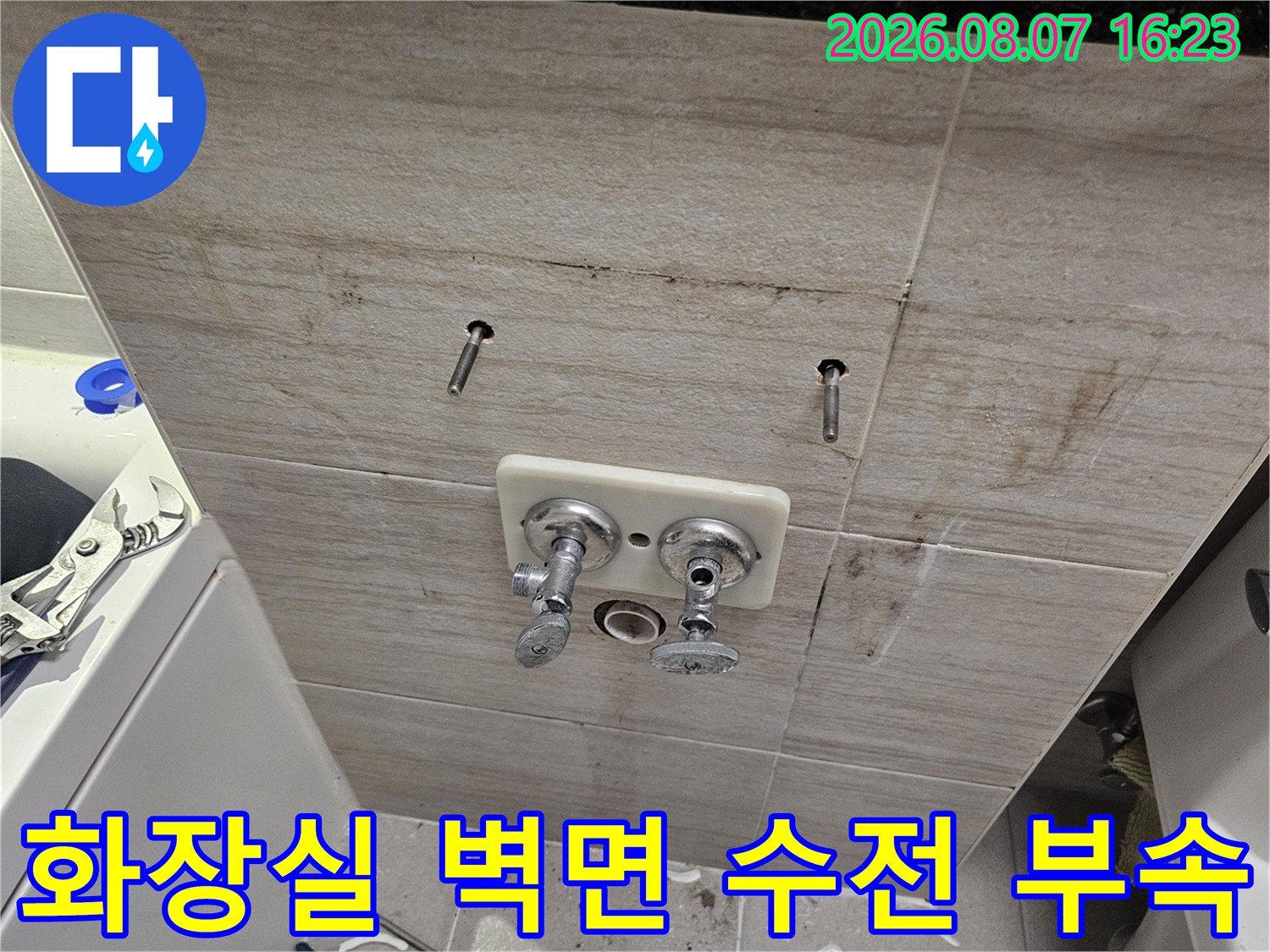 욕실 벽면 타일에 설치된 세면대용 수전 및 연결 부위