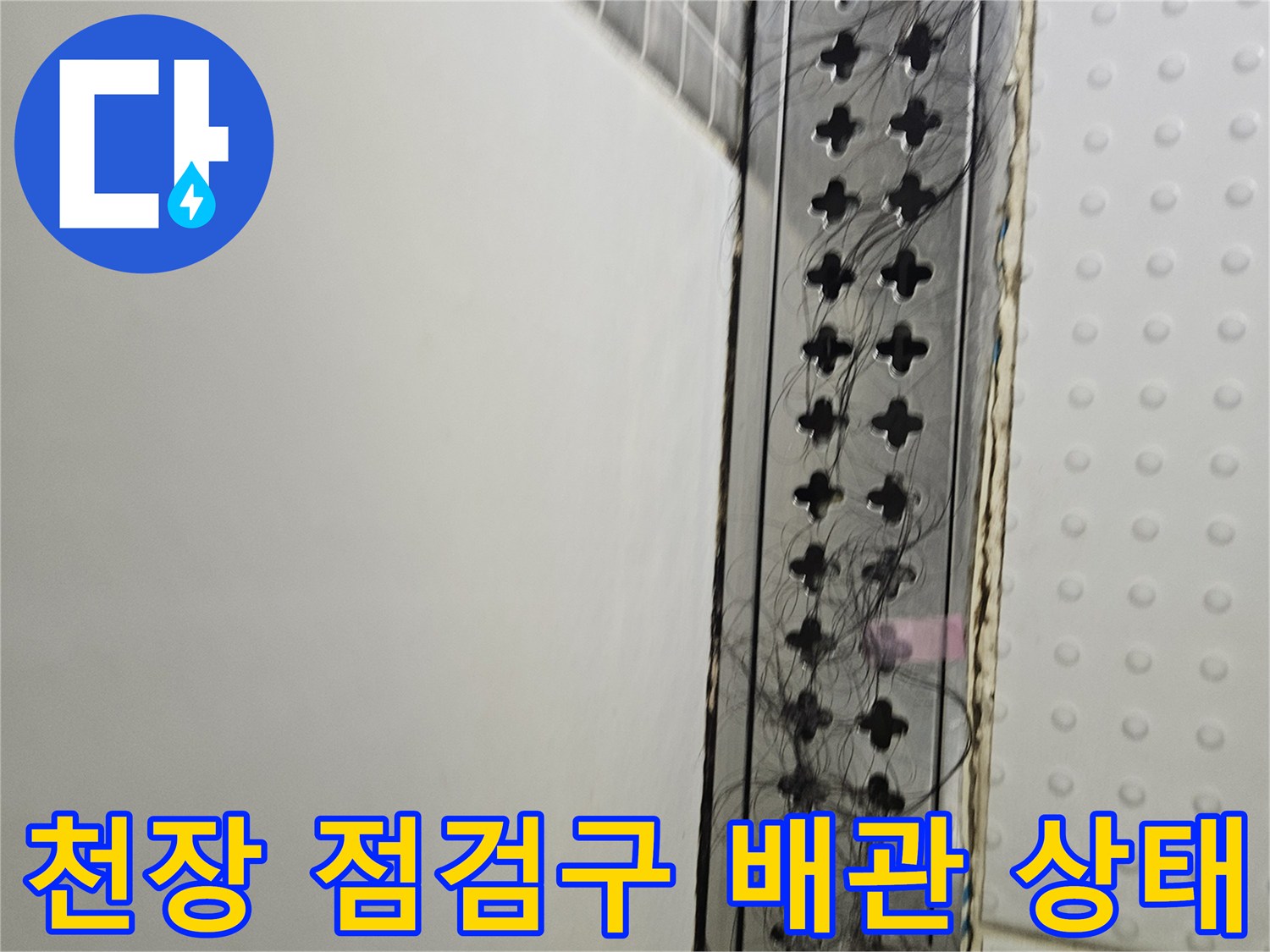아파트 천장 점검구 내부의 복잡한 배관과 전선 상태를 보여주는 사진입니다.
