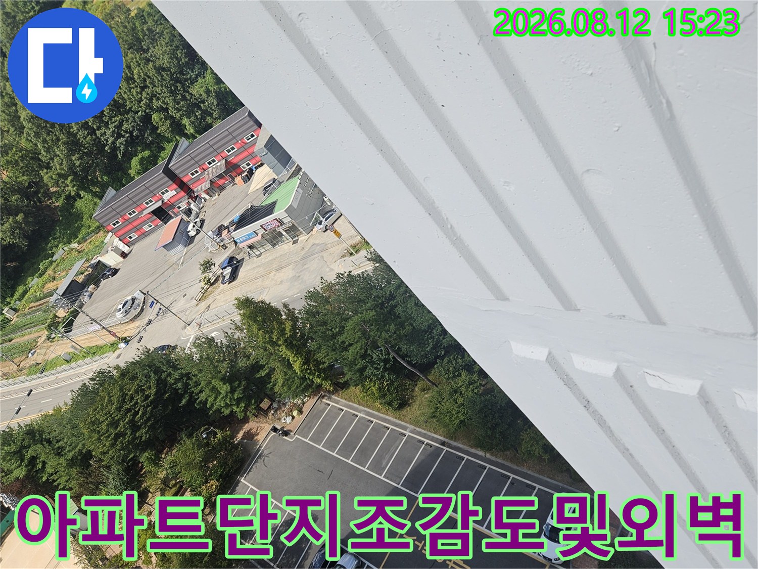 흰색 외벽 난간 너머로 보이는 아파트 주차장-전경 사진