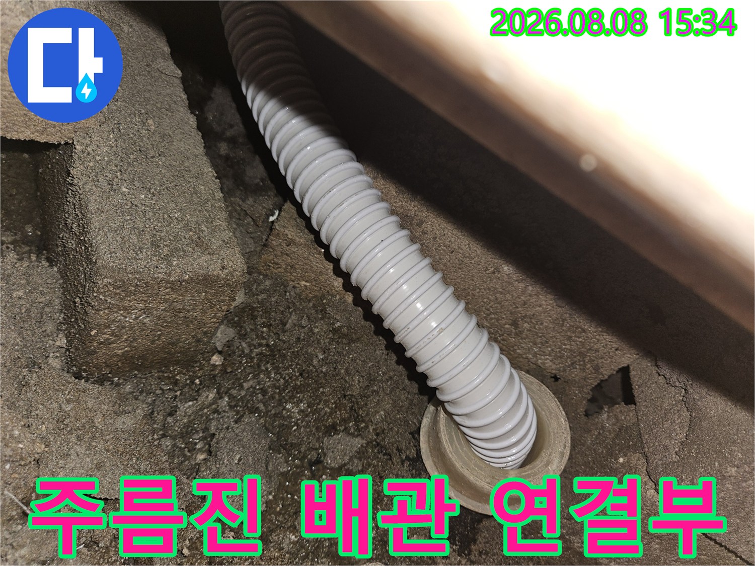 콘크리트 틈 사이로 연결된 하얀색 주름 배관