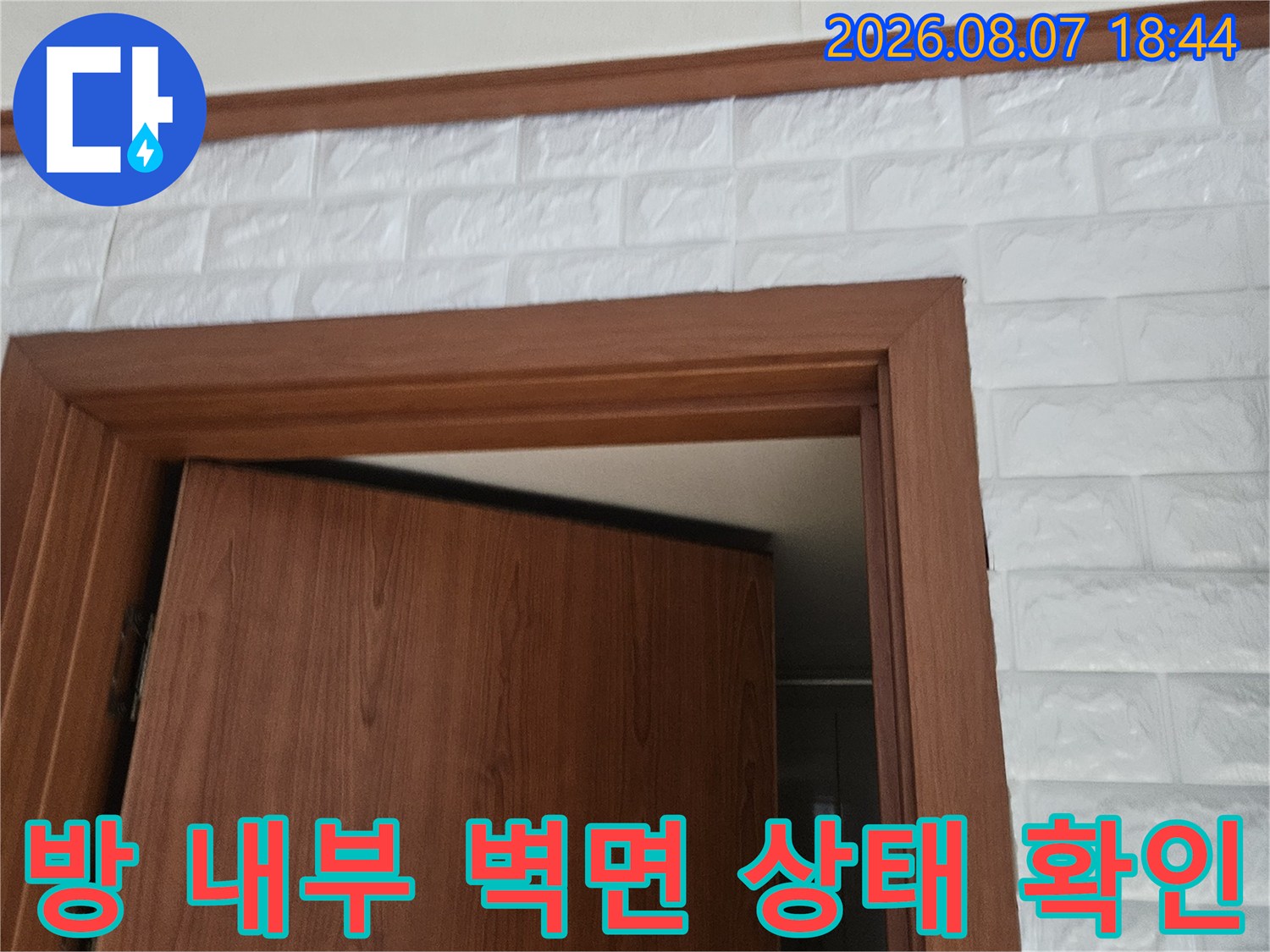 나무 문틀과 하얀색 입체 벽지가 만나는 경계 부위 촬영