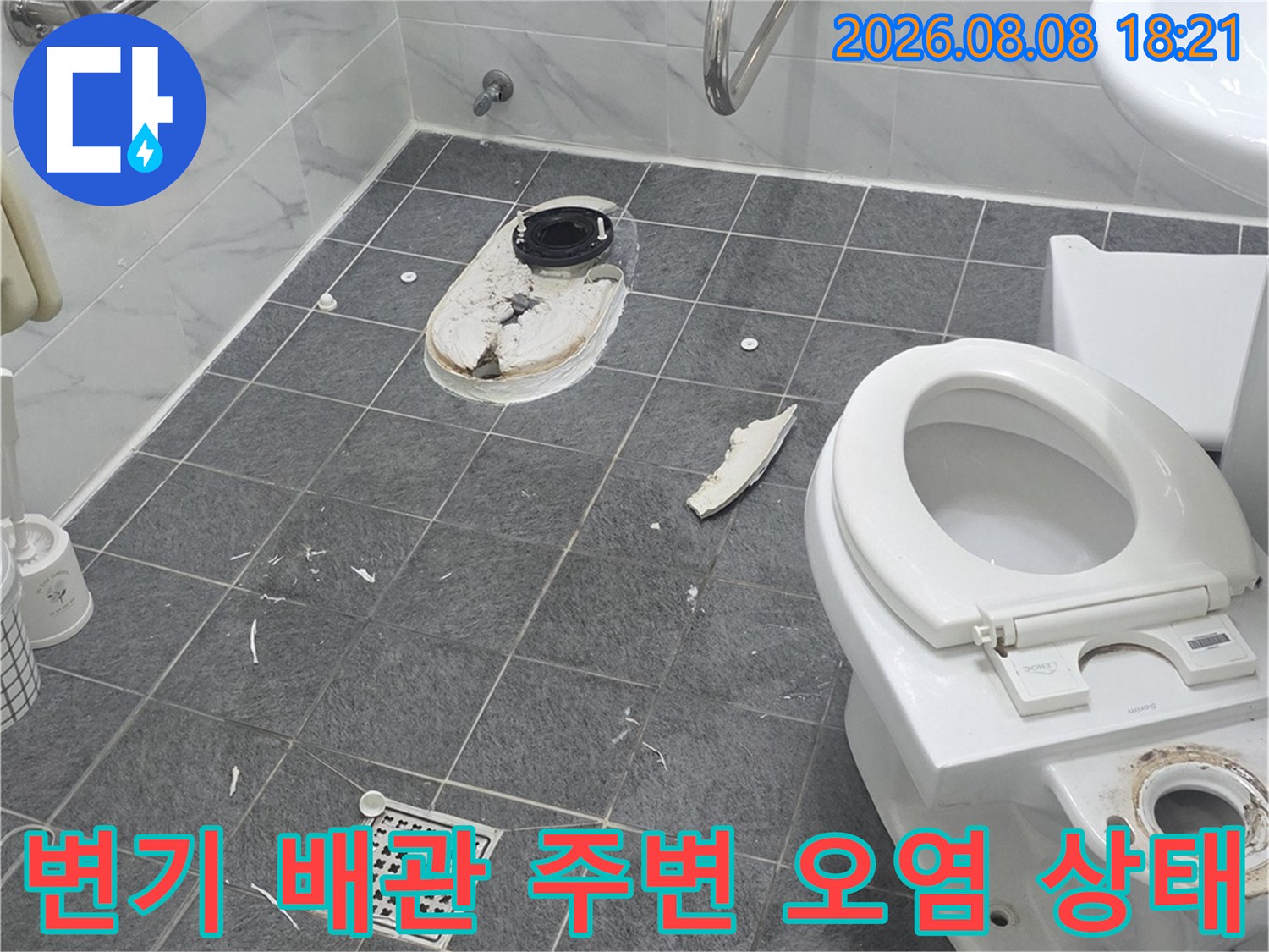 변기 아래쪽 배관 입구 주변에 고여 있는 오염된 물과 습기입니다.