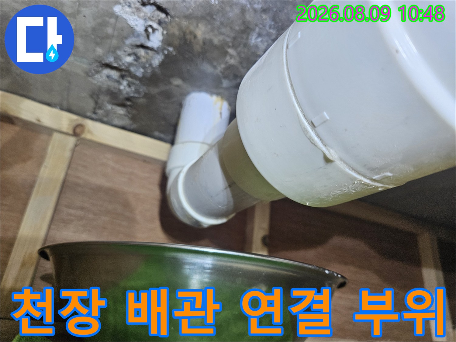 천장 아래로 노출된 하얀색 배수 배관의 연결 지점 사진입니다.