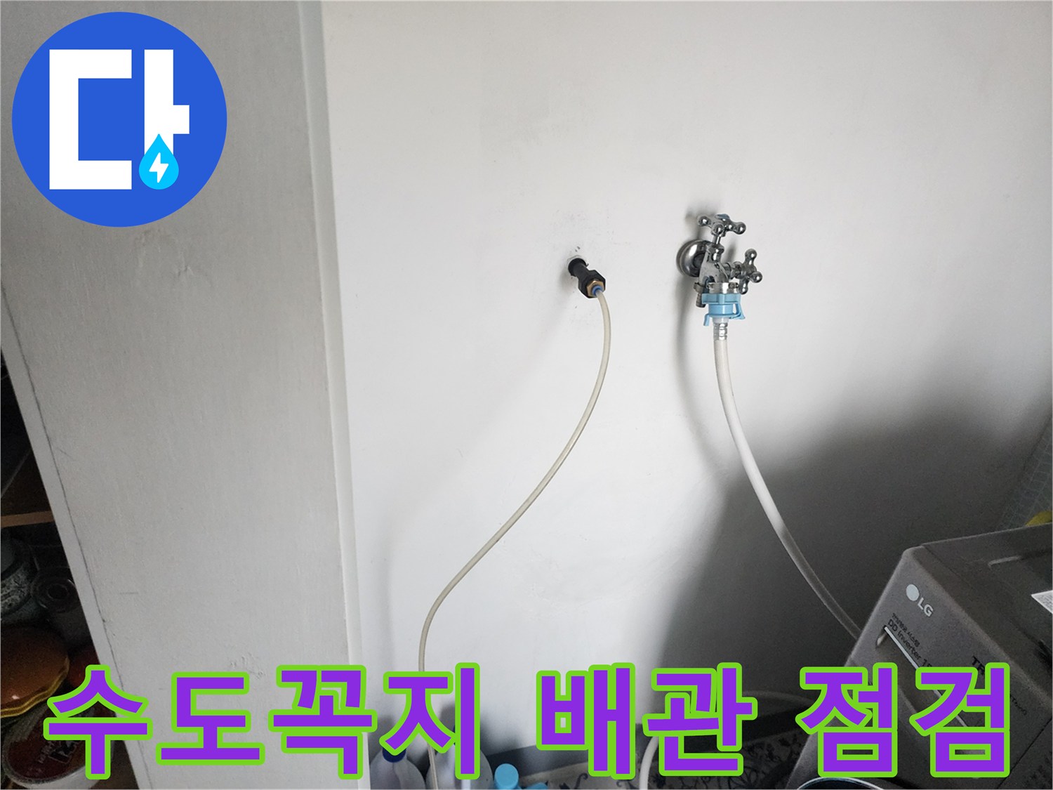 벽면에 설치된 수도 부속과 연결 호스의 상태를 촬영한 사진