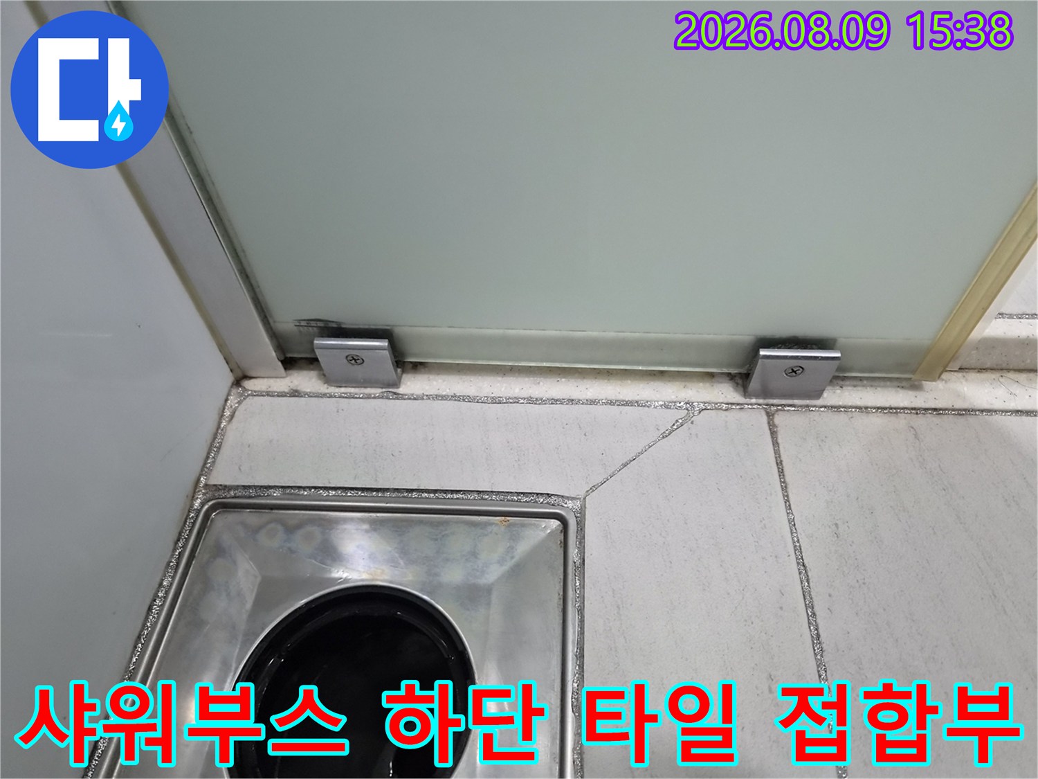 샤워실 바닥 배수구와 샤워부스 유리문 하단 부분 사진