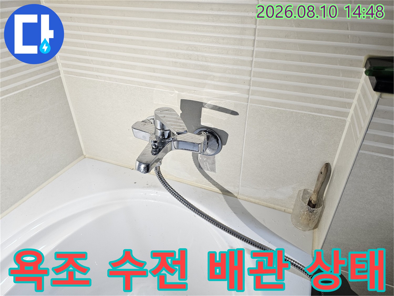 욕조 벽면 수전과 연결된 샤워기 호스 모습