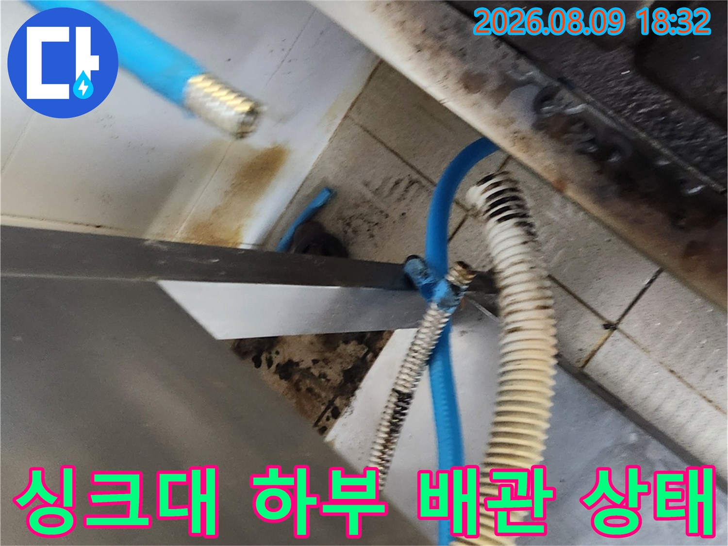 종로구 삼청동 주방 싱크대 밑에 노출된 파란색 호스와 오염된 배관 부위입니다.