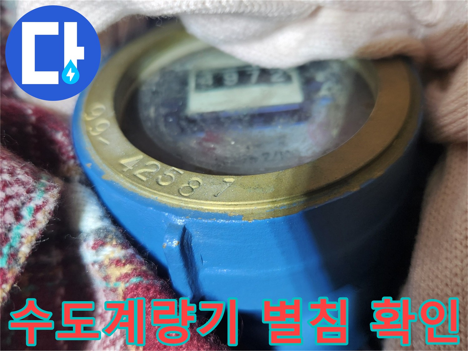 파란색 수도 계량기 내부의 숫자가 돌아가는 별침 상태를 근접 촬영한 사진
