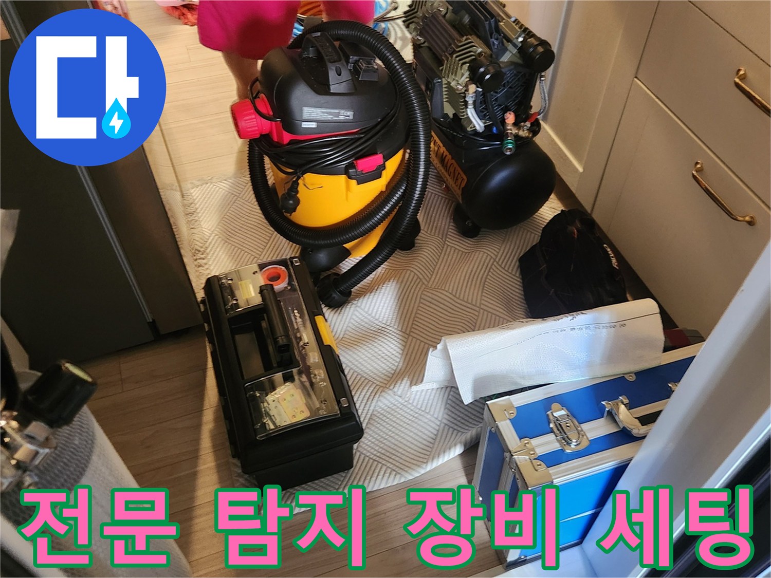 누수 지점 탐지를 위해 거실 바닥에 배치한 가스탐지기와 공기 압축기