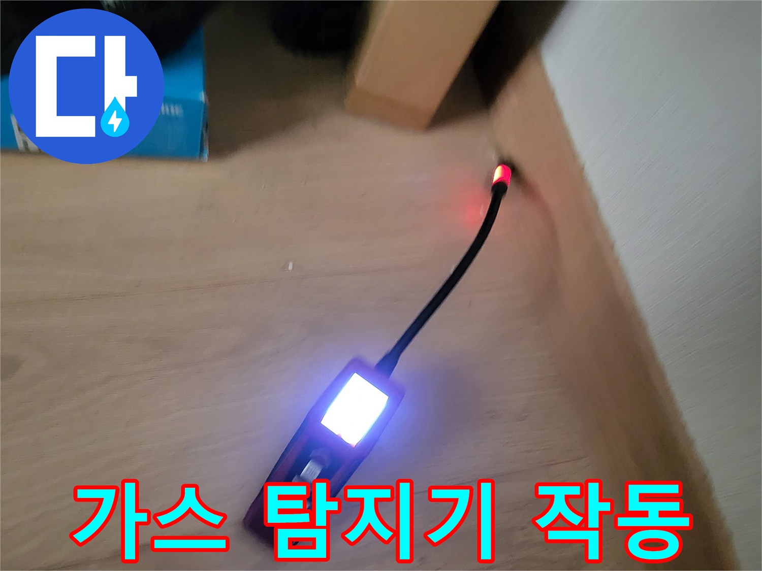 마루 바닥 위에서 가스 탐지기를 사용하여 누수 지점을 추적하는 모습