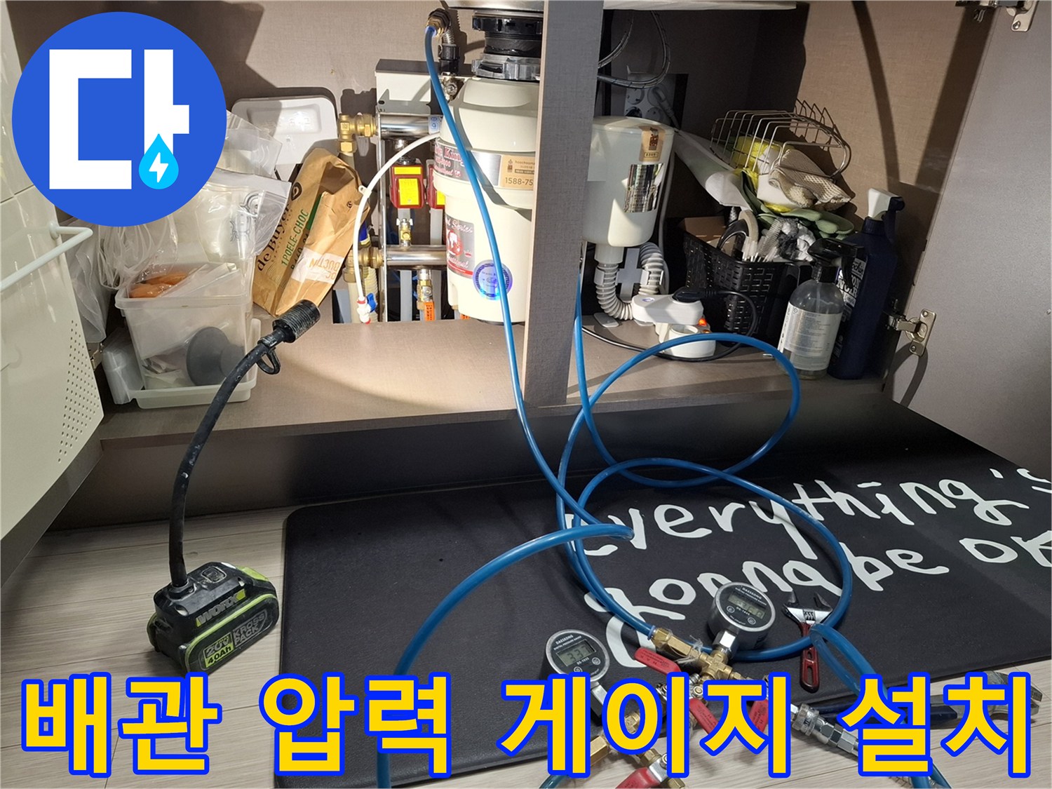 매립된 수전 분배기에 압력계를 연결하여 배관의 기밀성을 테스트하는 장면입니다.