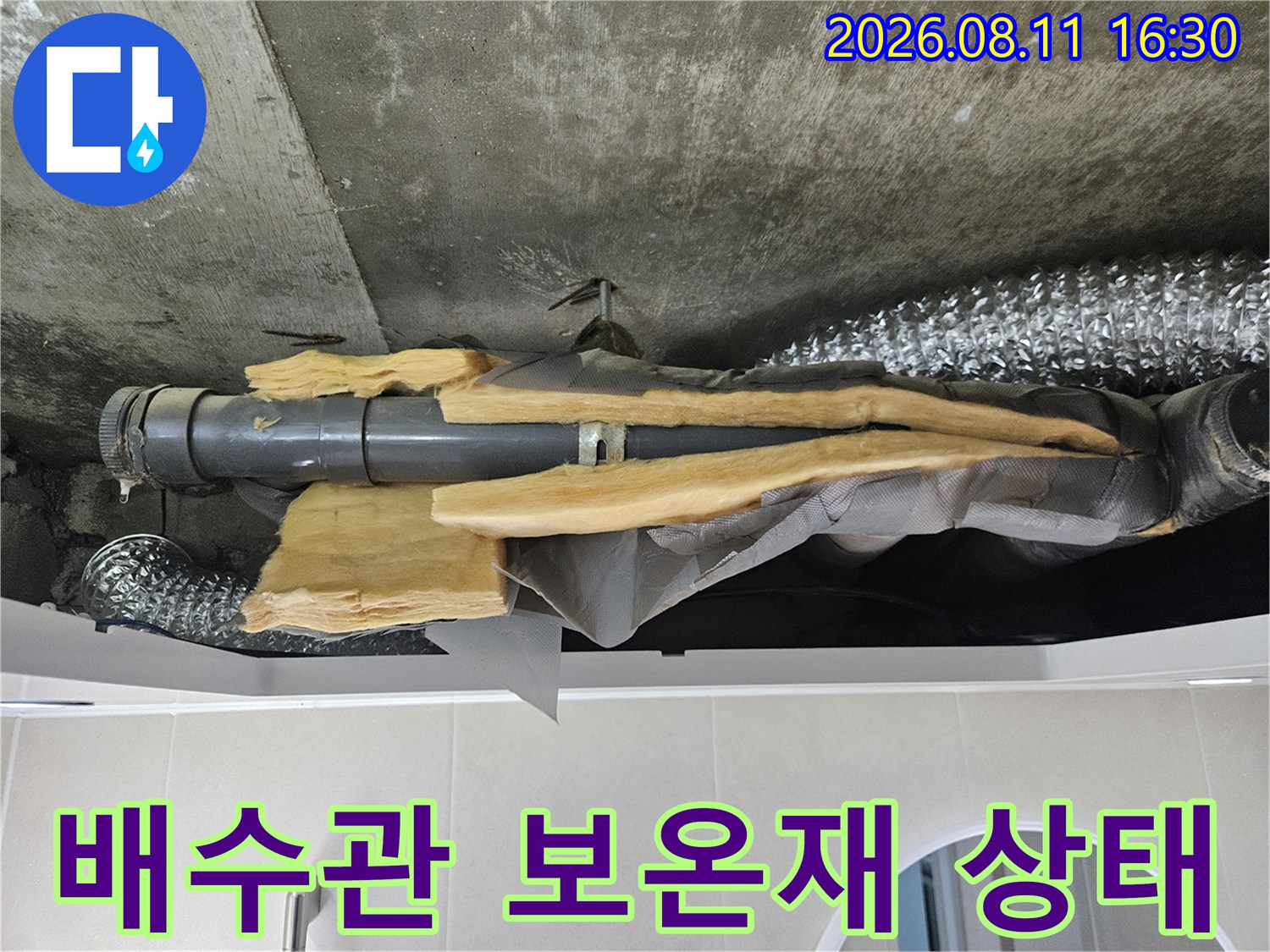 은박재로 감싸진 배수 배관과 천장 내부의 습한 환경을 보여주는 사진입니다.