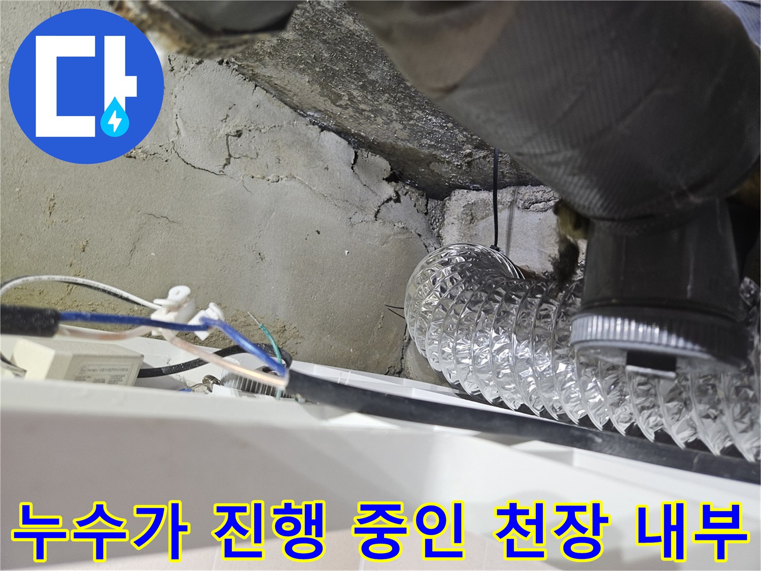 은색-자바라-호스와-그-아래로-물에-젖어-검게-변한-콘크리트-균열-부위
