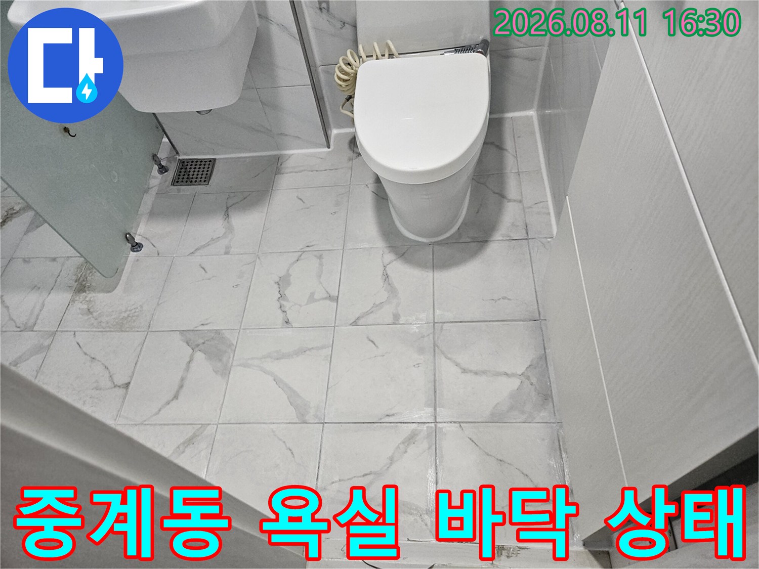 화장실 변기와 세면대 주변의 타일 시공 모습