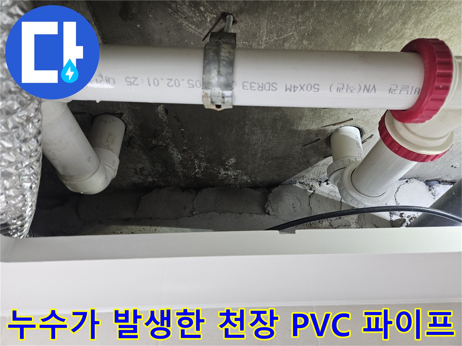 화장실 천장에 설치된-노후된 배관 연결 부위와 붉은색 캡 모습