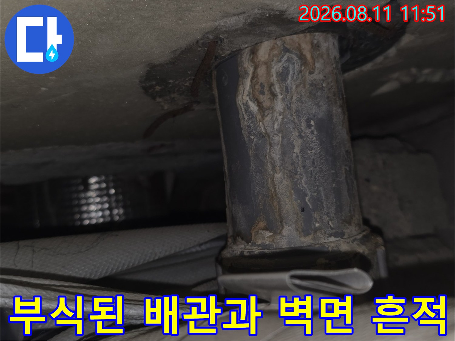 베란다 배관 부위-금속 배관의 부식과 주변 벽면의 변색 상태를 보여줍니다.