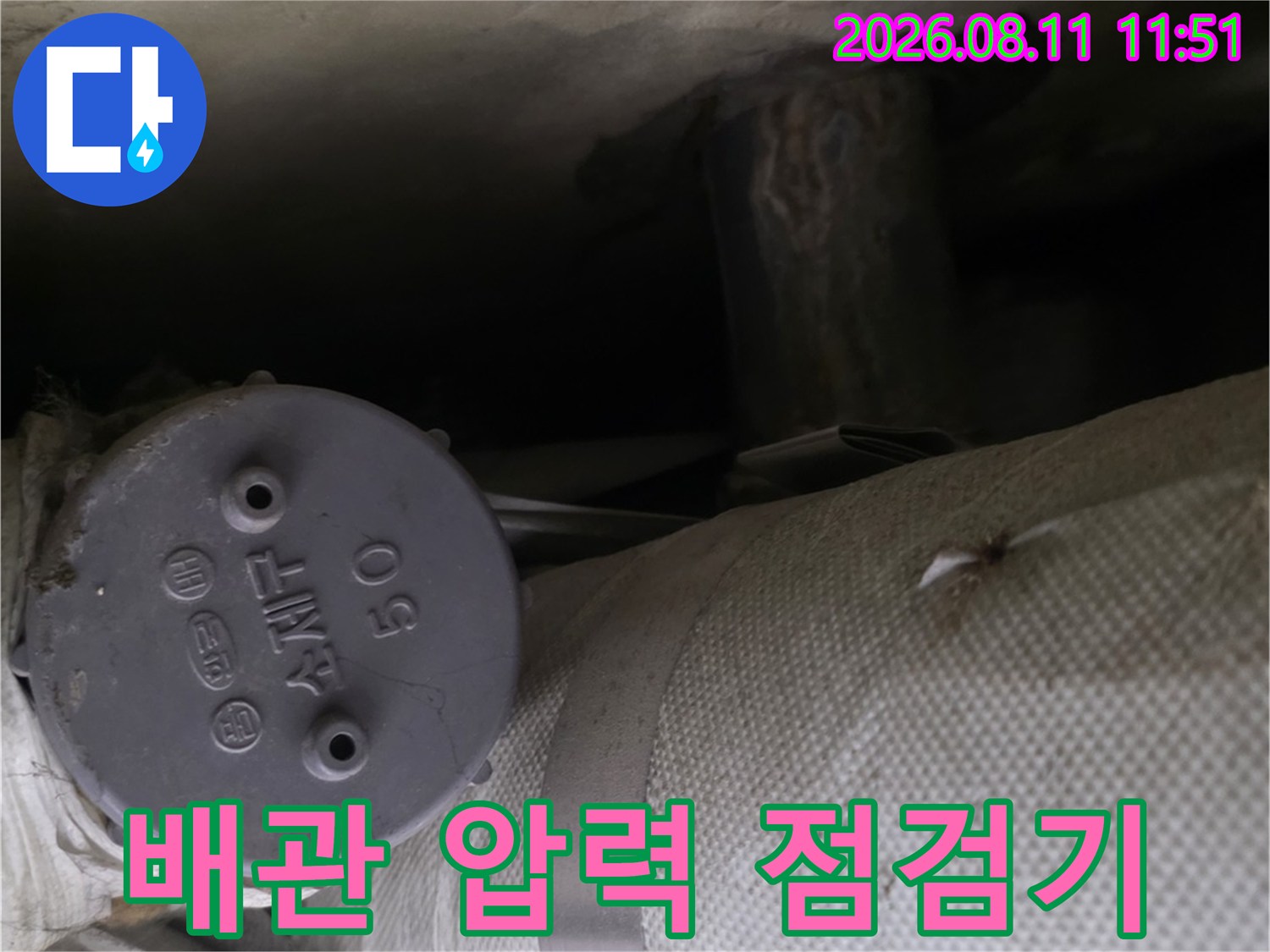 하얀색 보온재 배관과 숫자가 적힌 둥근 압력계의 모습입니다.