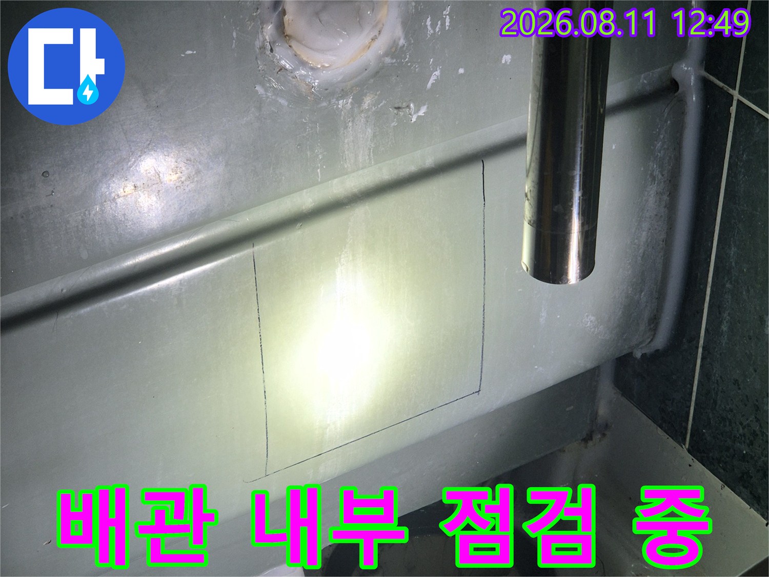 절개된 욕조 패널 사이로 배관 상태를 정밀하게 점검하고 있습니다.