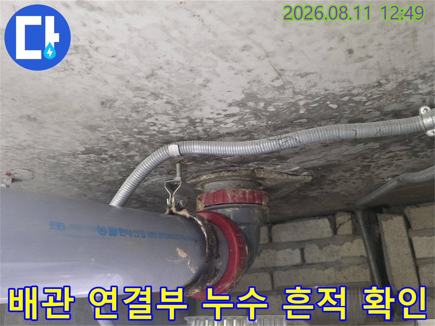 천장 내부 배관-욕조 배수 배관의 연결 부위와 습기 상태를 보여줍니다.