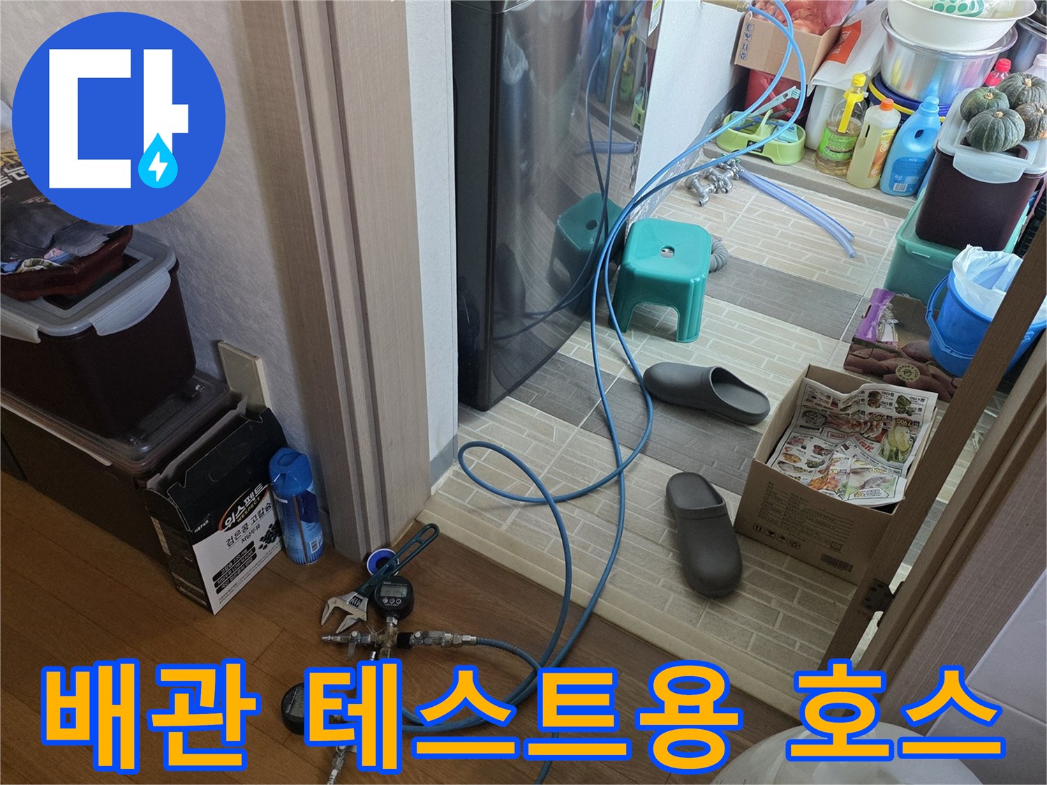 바닥에 연결된 파란색 공압 테스트용 호스와 게이지 장치