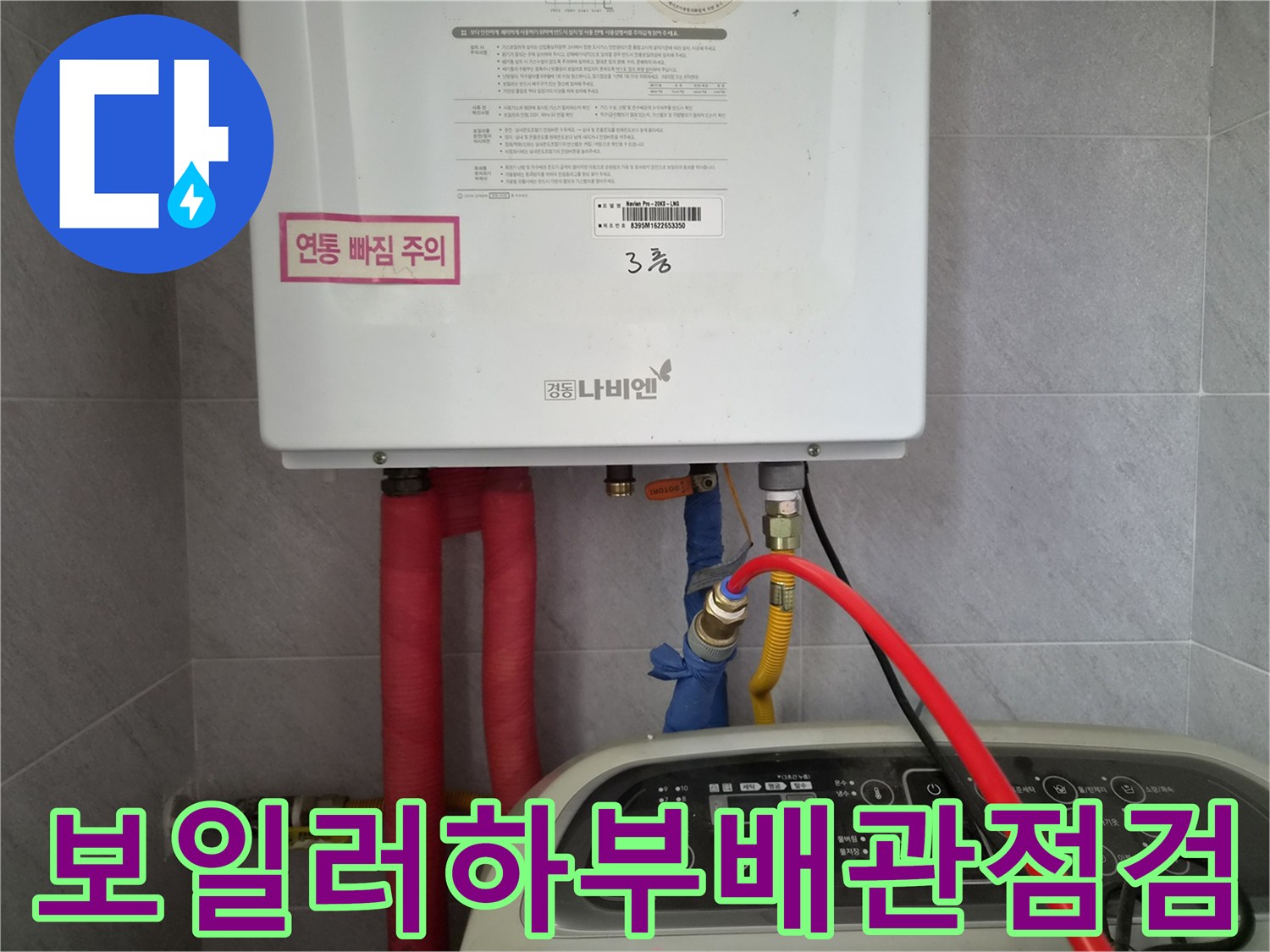 보일러 하단에 연결된 빨간색 온수 배관과 앵글밸브 상태를 확인하는 모습