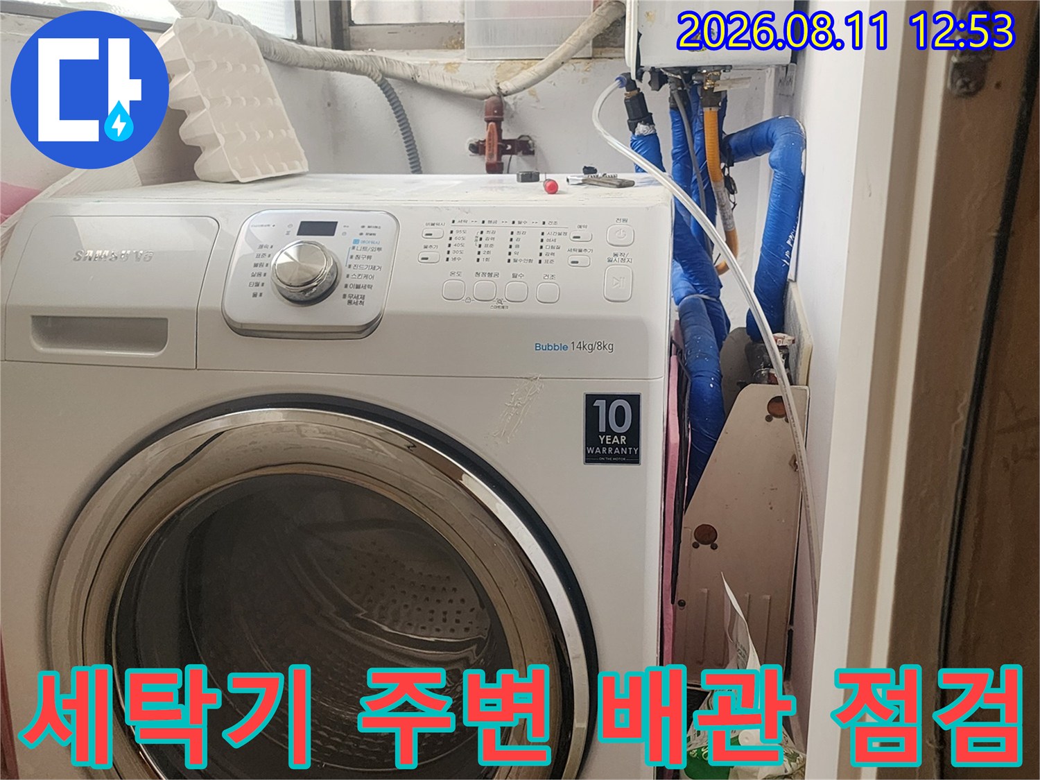 세탁기 옆으로 노출된 파란색 수도 관로와 보일러 장치의 연결 상태입니다.
