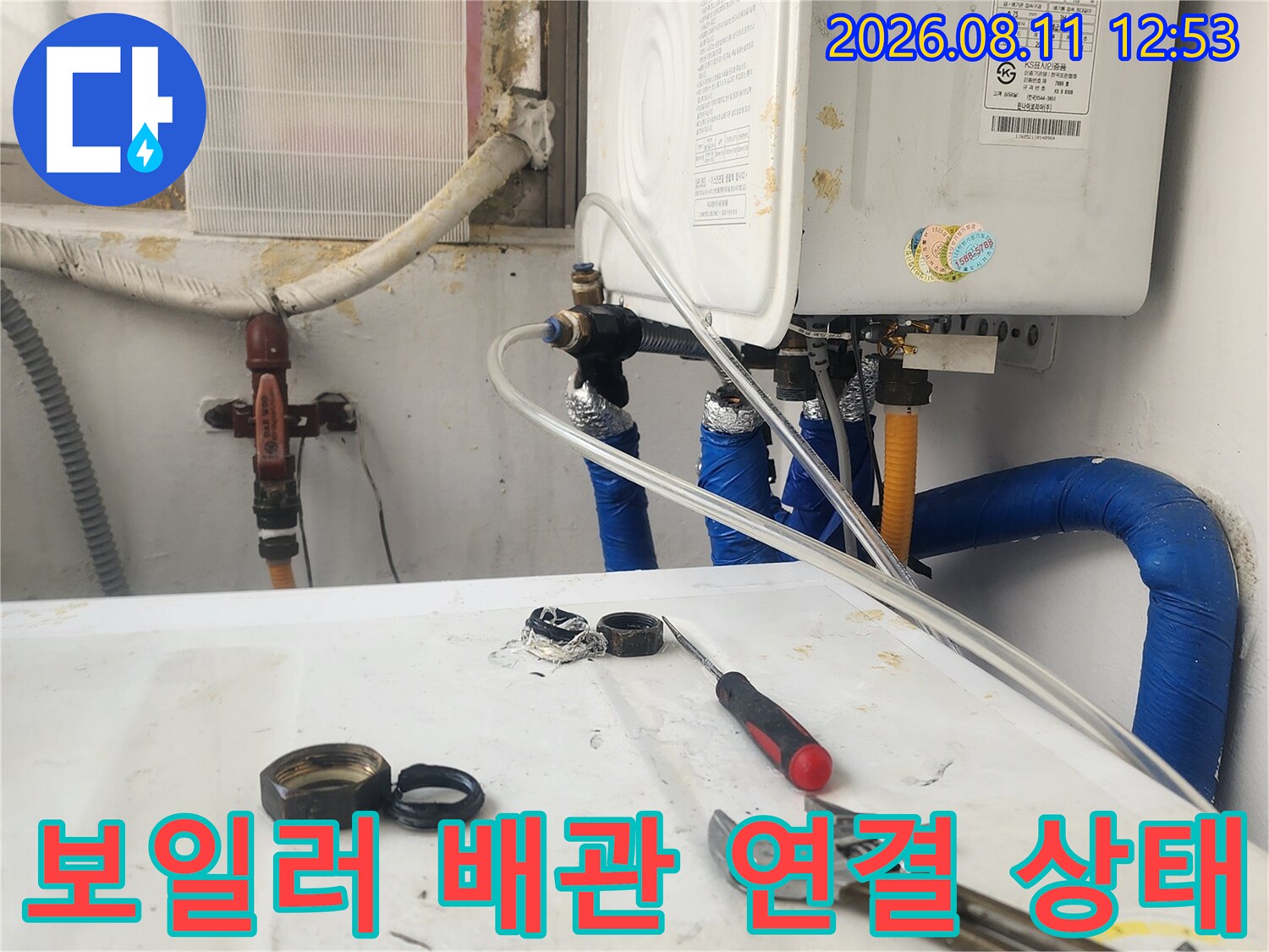 파란색 보온재로 감싸진 보일러 배관과 공구 배치 모습