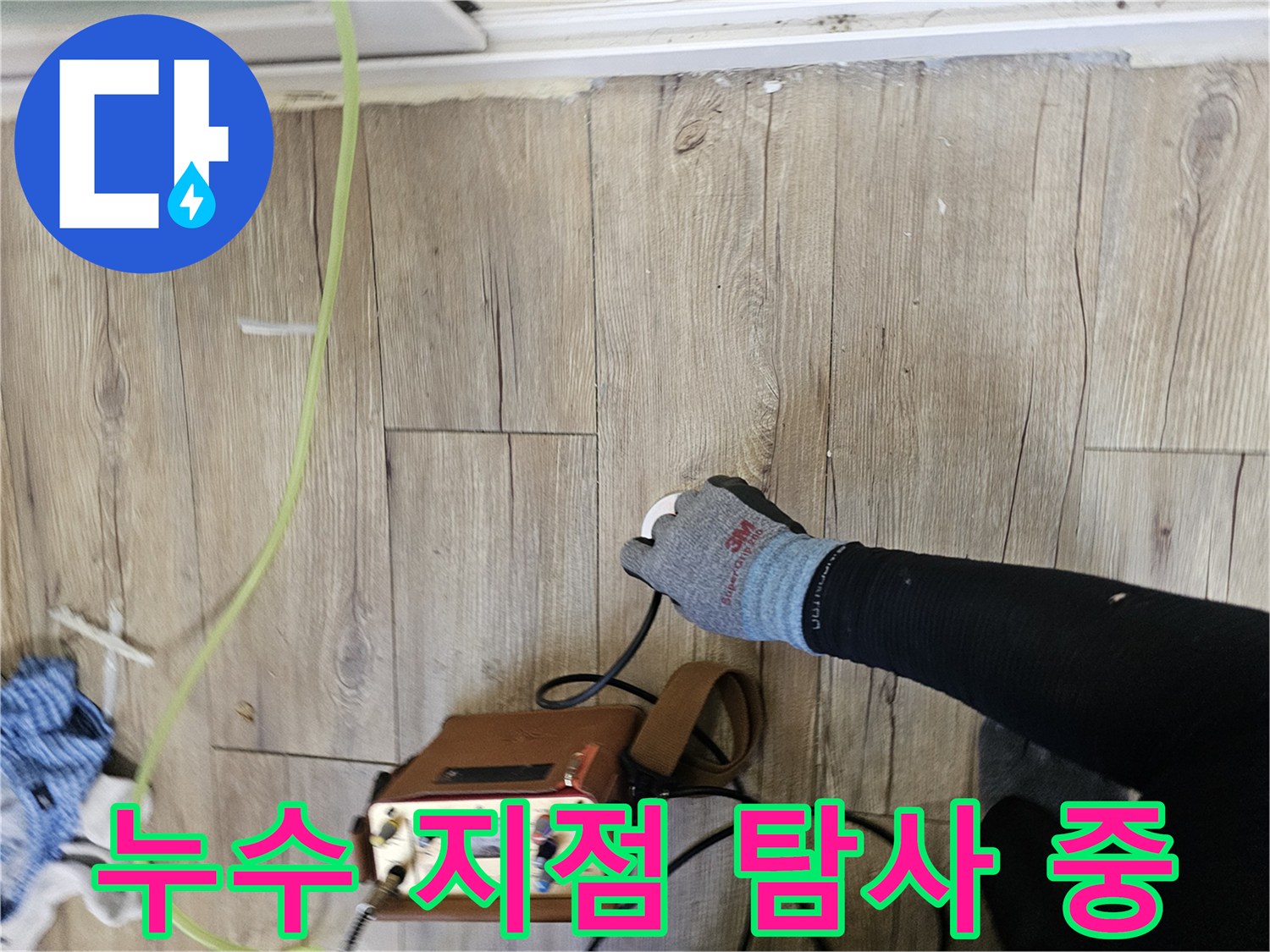 바닥 마루 위에서-배관 누수를 찾고 있는 전문 장비와 손