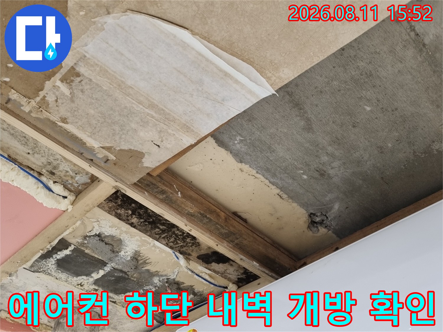 삼성 에어컨 아래쪽 벽체를 일부 제거하여 내부의 젖은 단열재와 오염 상태를 노출시킨 장면