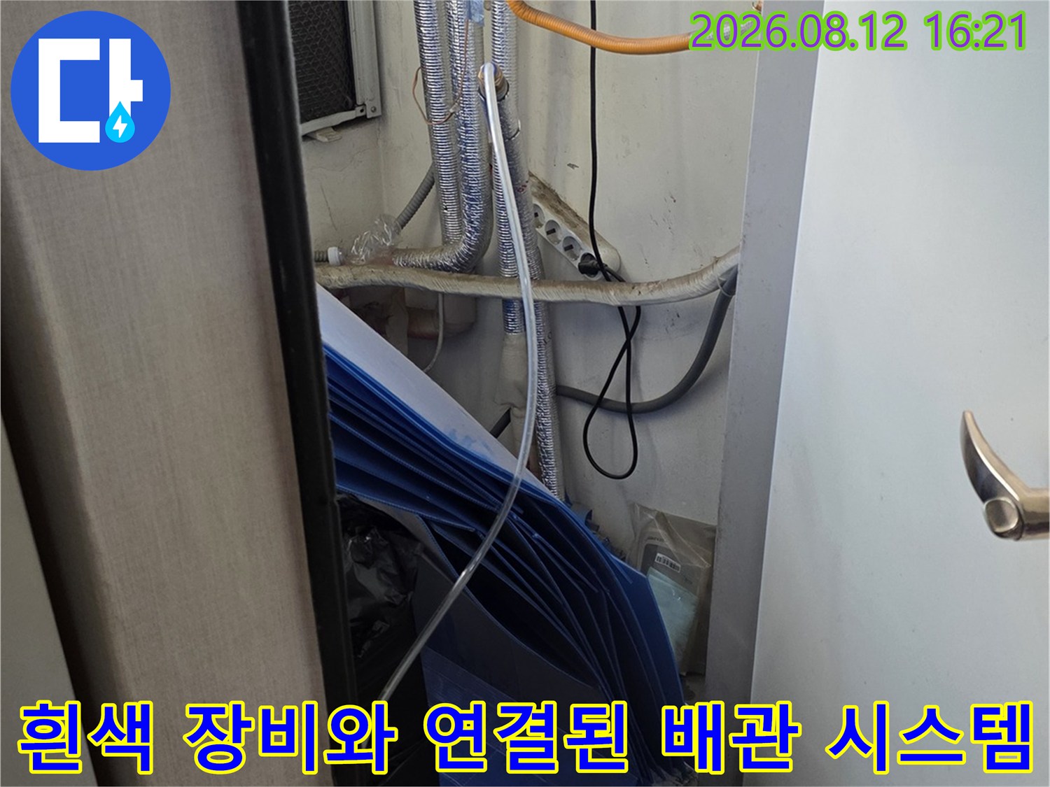 욕실 내부에 설치된 기계 장치와 은색 단열재가 감싸진 배관들의 연결 모습