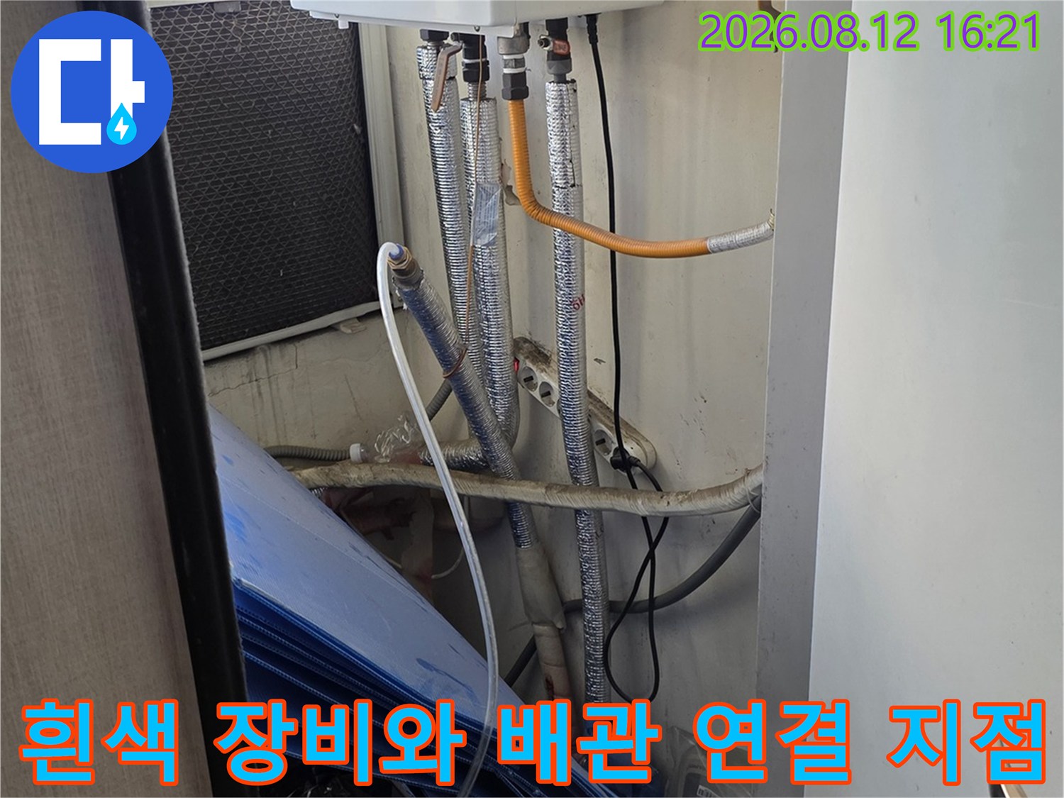 천장 점검구 안쪽의 흰색 보일러 설비와 은색 주름관-연결 부위 확대 모습