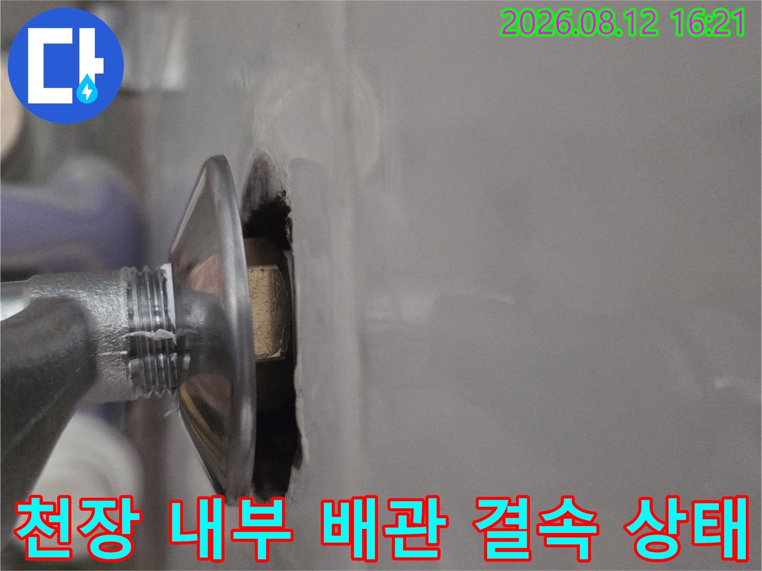 천장 타공 부위를 통해 드러난 금속제 배관 연결 너트 부분