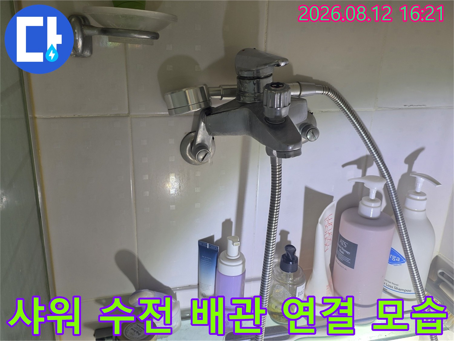흰색 타일 벽면에 설치된 욕실 샤워기 수전과 호스-정밀 점검 사진
