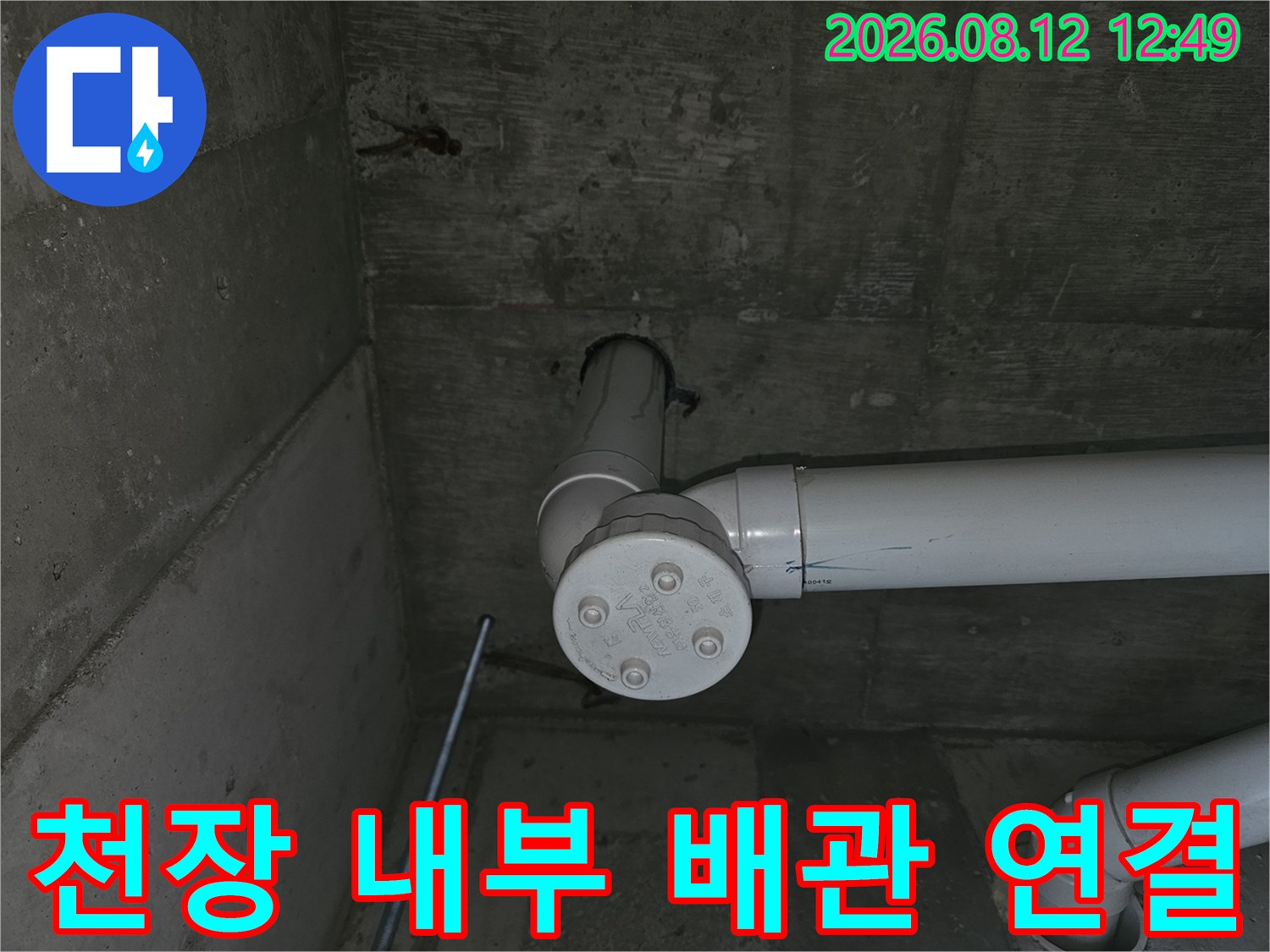 콘크리트 천장 아래에 - 설치된 흰색 배수 배관의 모습입니다.