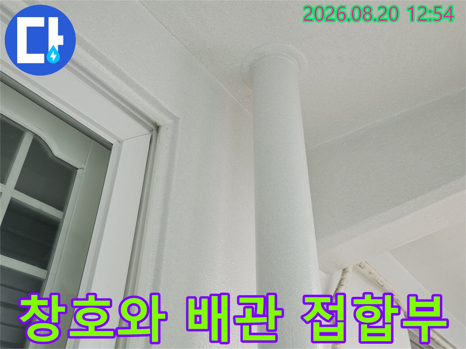 흰색 우수관과 천장 마감재가 만나는 경계 부분을 촬영한 이미지입니다